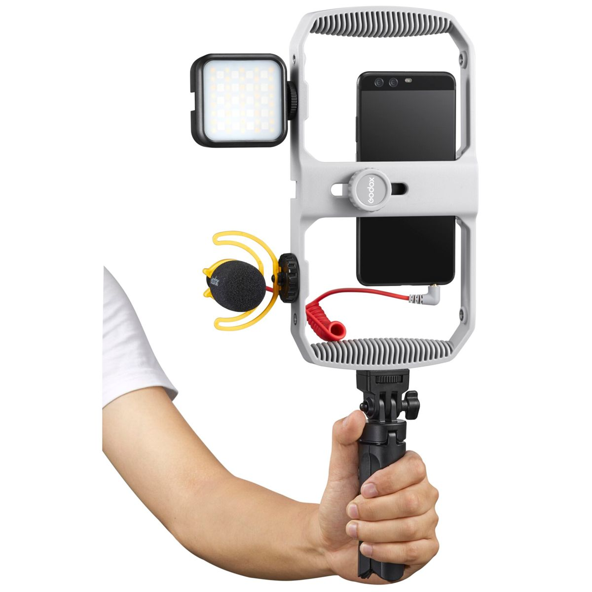 Hand hält ein Smartphone-Rig mit Licht und Mikrofon.