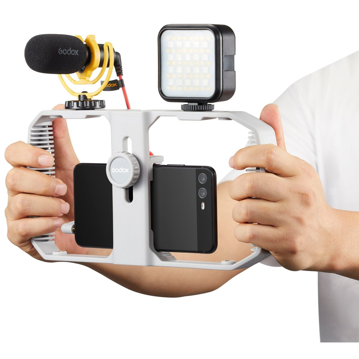 Ein Mann hält ein Smartphone-Rig mit Mikrofon und LED-Licht.