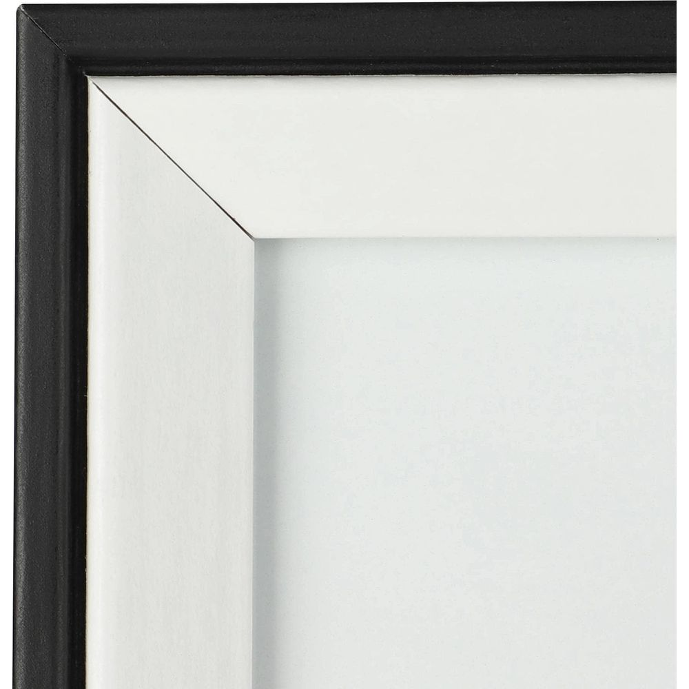 Gros plan du bord d'un cadre noir avec un passe-partout blanc.
