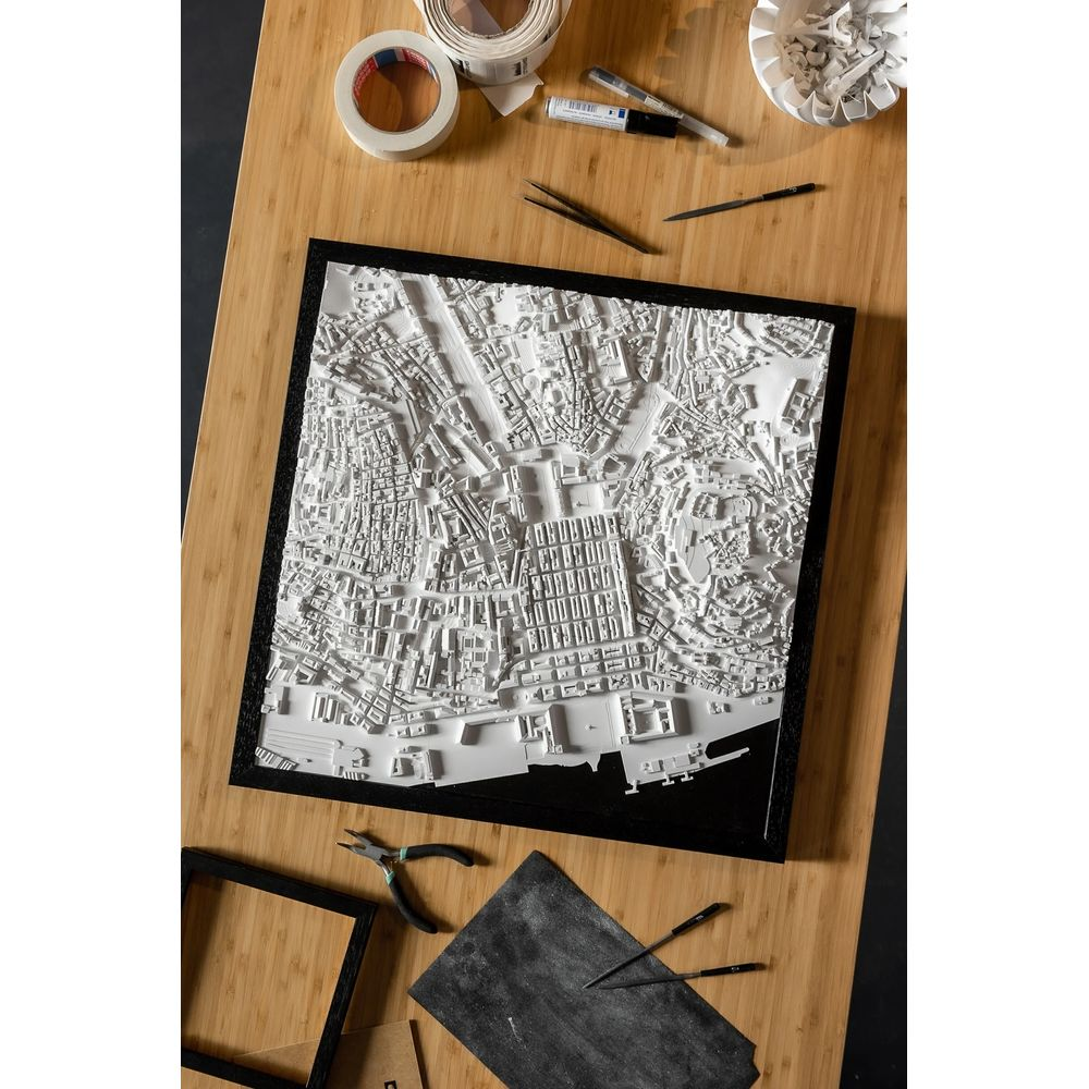 Une carte de ville 3D blanche avec des bâtiments et des rues sur une table en bois.