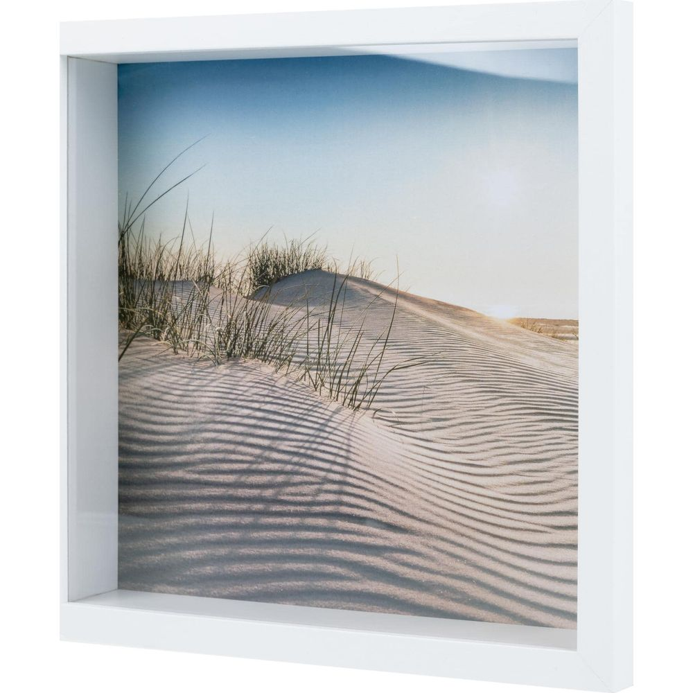 Gerahmtes Bild von Sanddünen mit Gräsern und Schatten im Sonnenlicht.