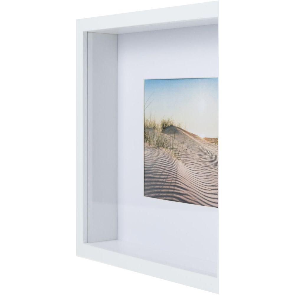 Gerahmtes Bild einer Sanddüne mit Gräsern bei Sonnenuntergang.