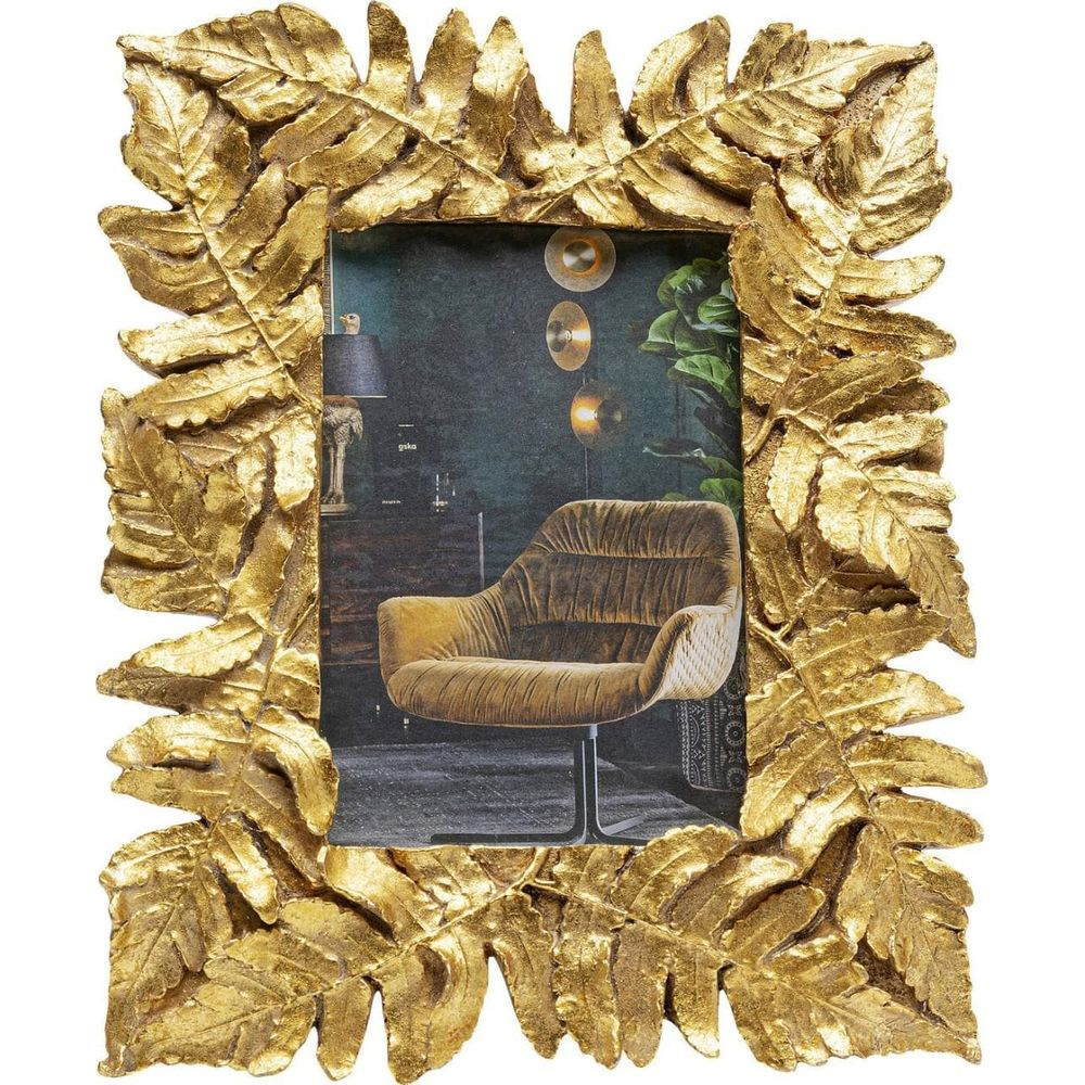 Cadre photo doré à motif de feuilles montrant un salon avec fauteuil.