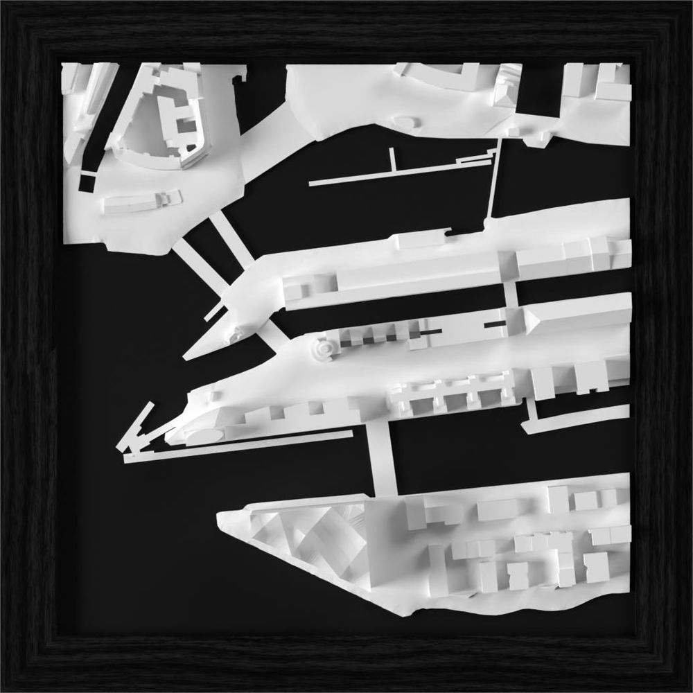 Maquette architecturale blanche d'un port avec bâtiments et quais sur fond noir.