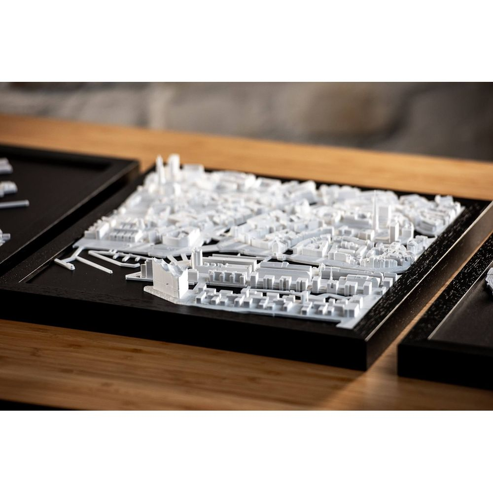 Un modèle 3D de ville blanc avec de nombreux bâtiments sur un cadre noir.