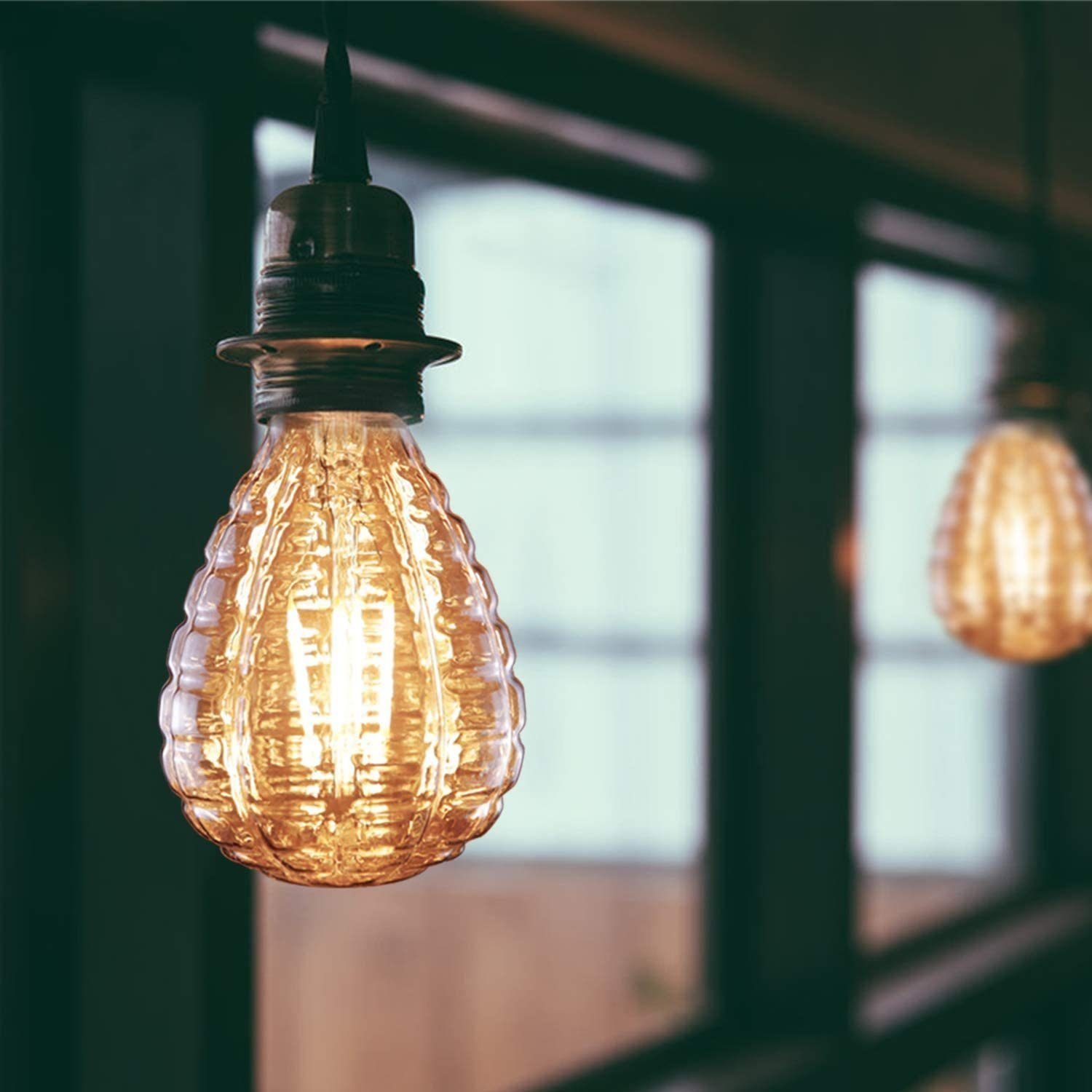 Eine glühbirnenförmige Lampe mit strukturiertem Glas hängt.