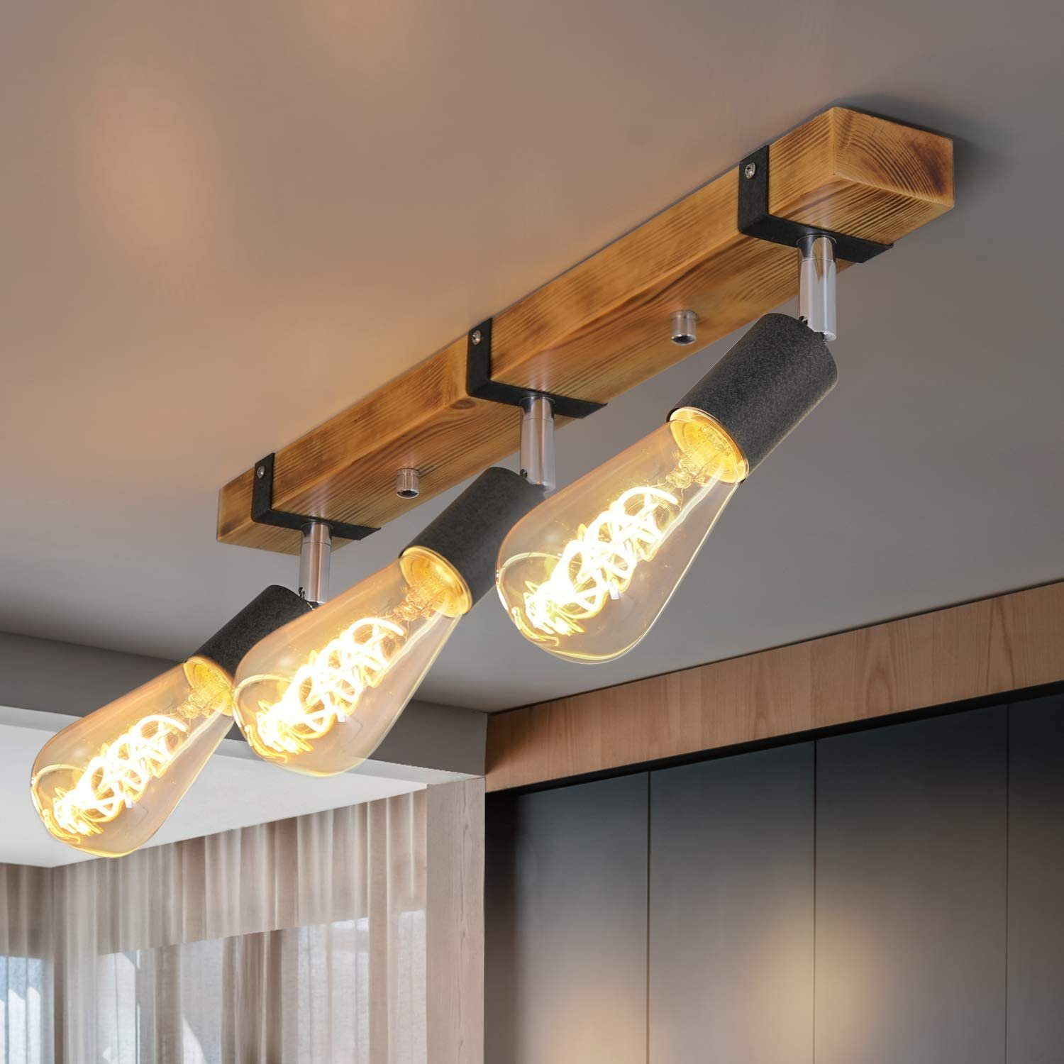 Drewniana lampa sufitowa z trzema żarówkami Edison i ciemnymi oprawkami.