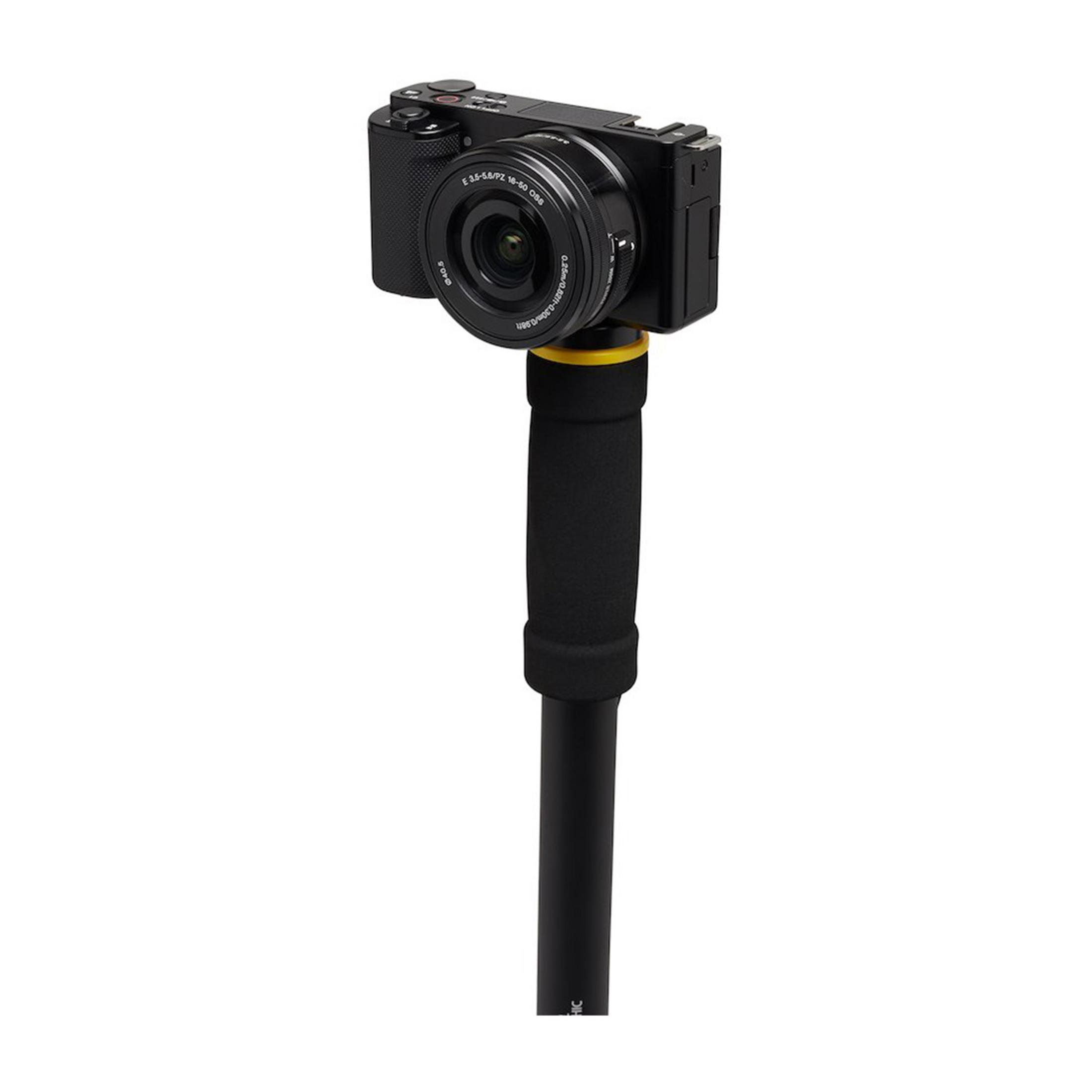 Una fotocamera nera compatta con obiettivo, montata su un'impugnatura gimbal nera imbottita.