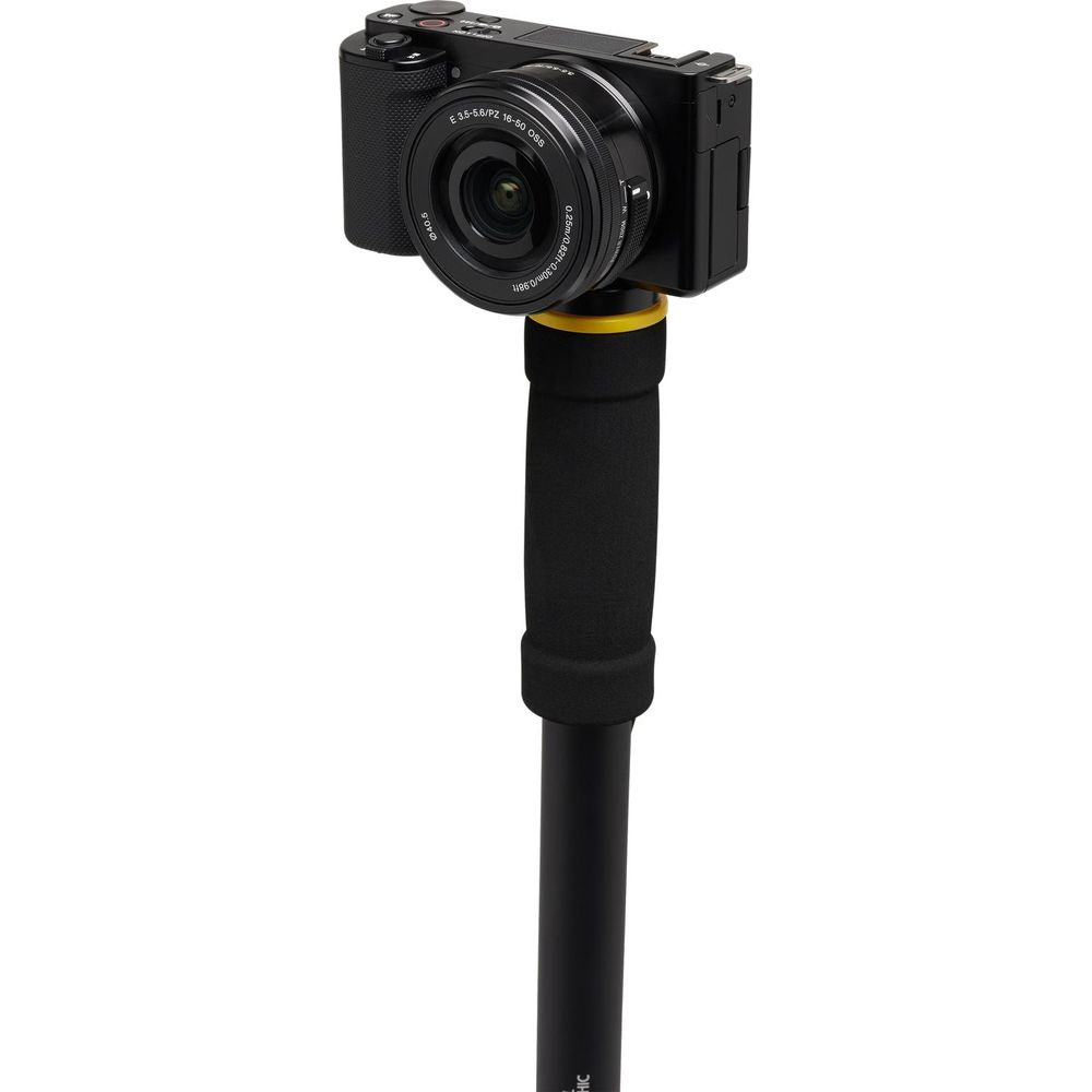Una fotocamera nera con obiettivo è montata su un manico nero con accento giallo.