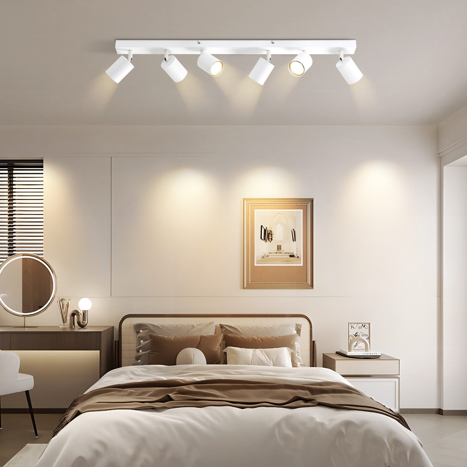Un juego de focos de techo blancos ilumina una cama con almohadas y mantas marrones.