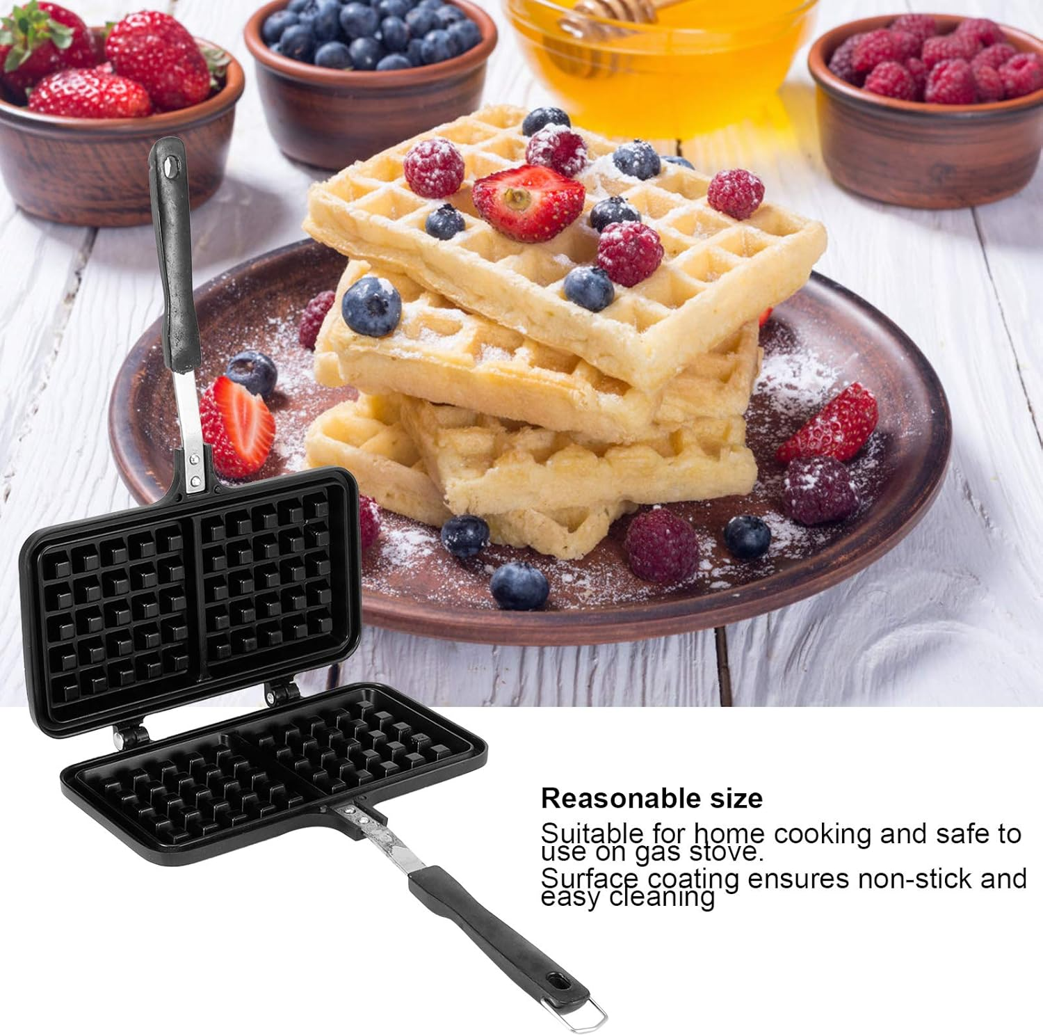 Ein offener Waffelmaker neben gestapelten Waffeln mit Beeren und Honig.