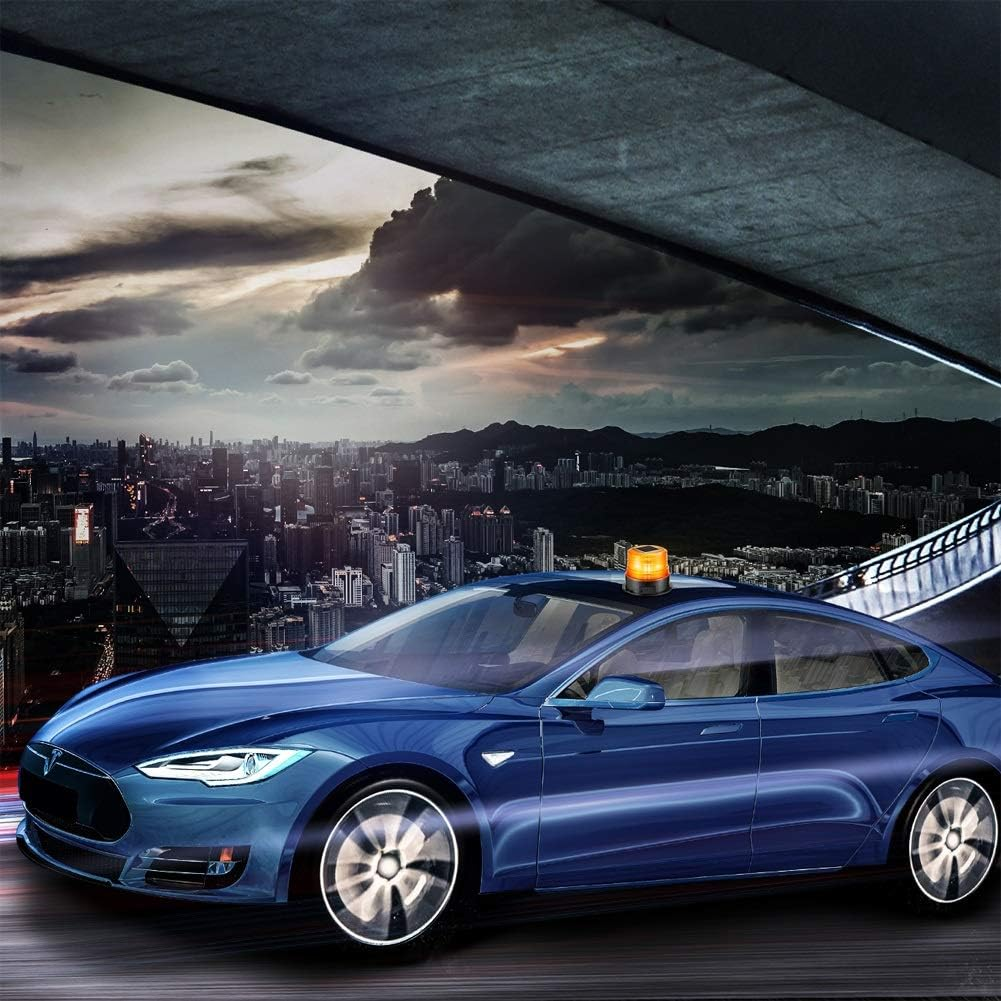 Ein blauer Tesla mit orangem Blinklicht fährt in der Dämmerung durch eine Stadt.