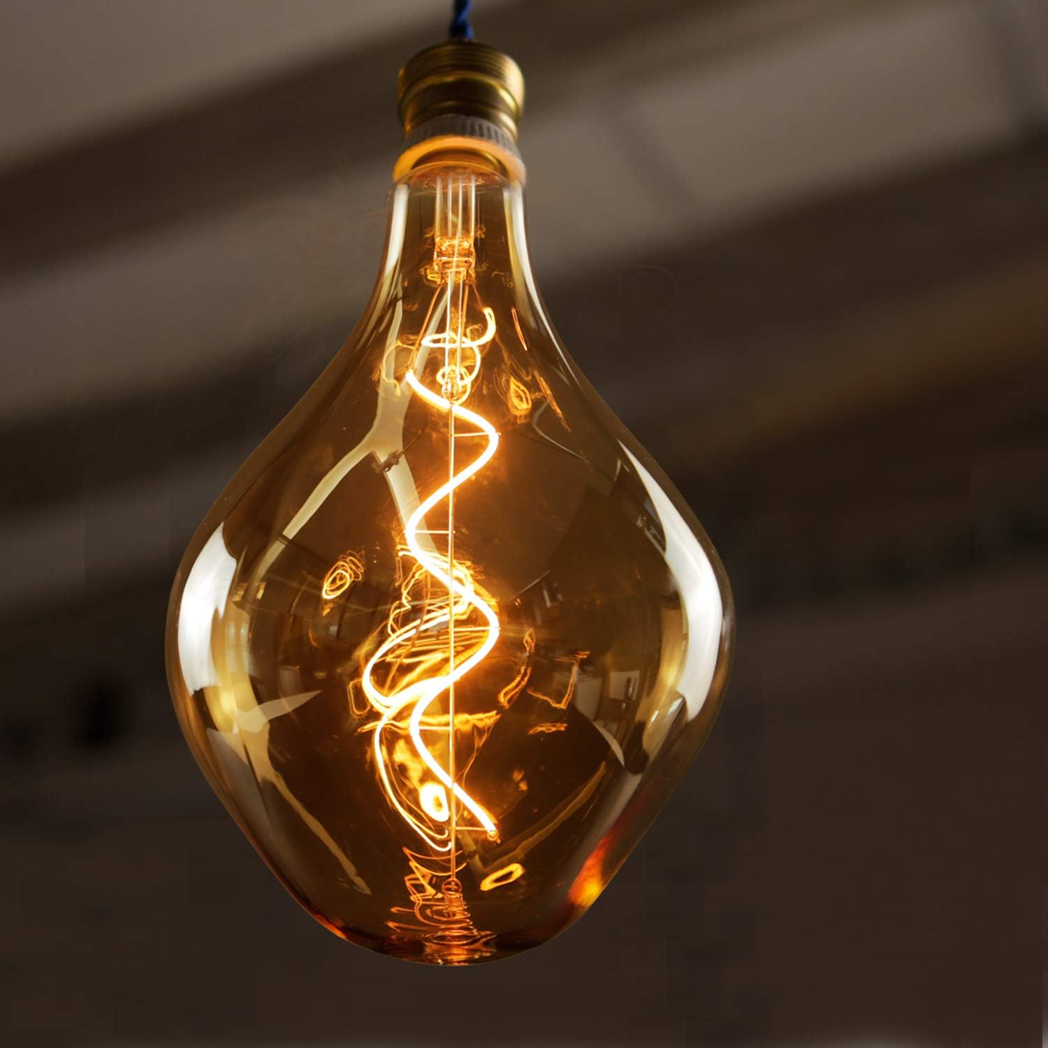 Eine große Edison-Glühbirne mit sichtbarem, gewundenem Glühfaden hängt von einem blauen Kabel.