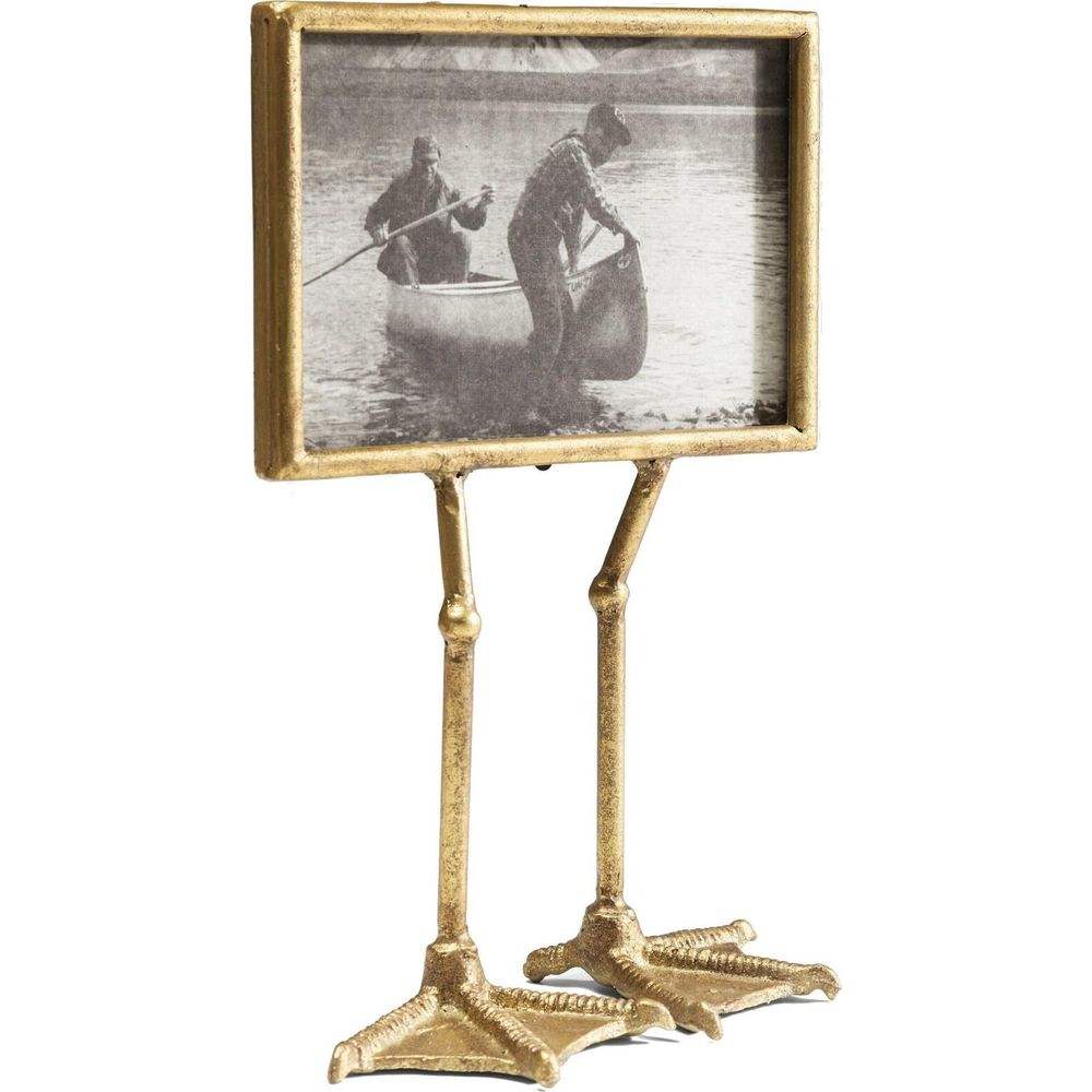 Cadre photo doré sur un support à pattes de canard avec image de deux hommes en canoë sur un lac.