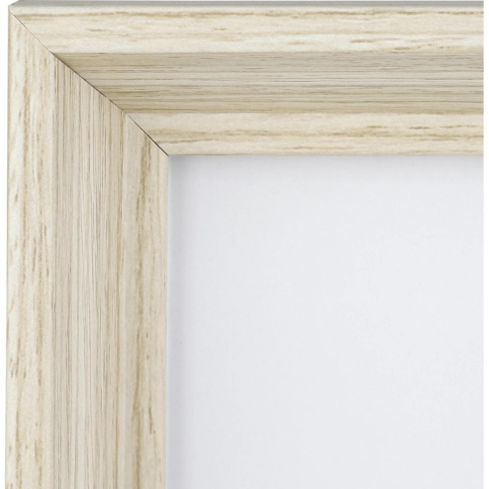 Gros plan d'un coin de cadre en bois clair à grain contre un fond blanc.