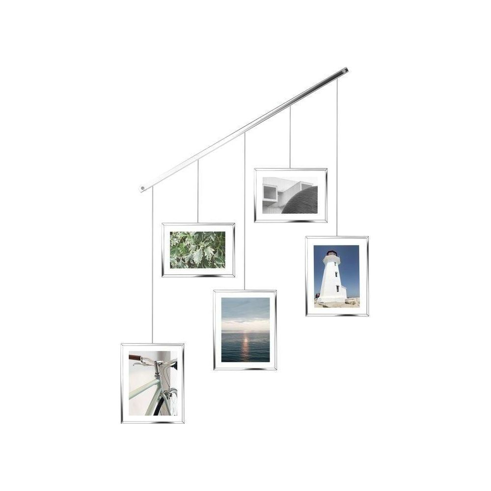 Eine mobile Ausstellung von vier silber gerahmten Fotos: Fahrrad, Blätter, Meer, Leuchtturm.