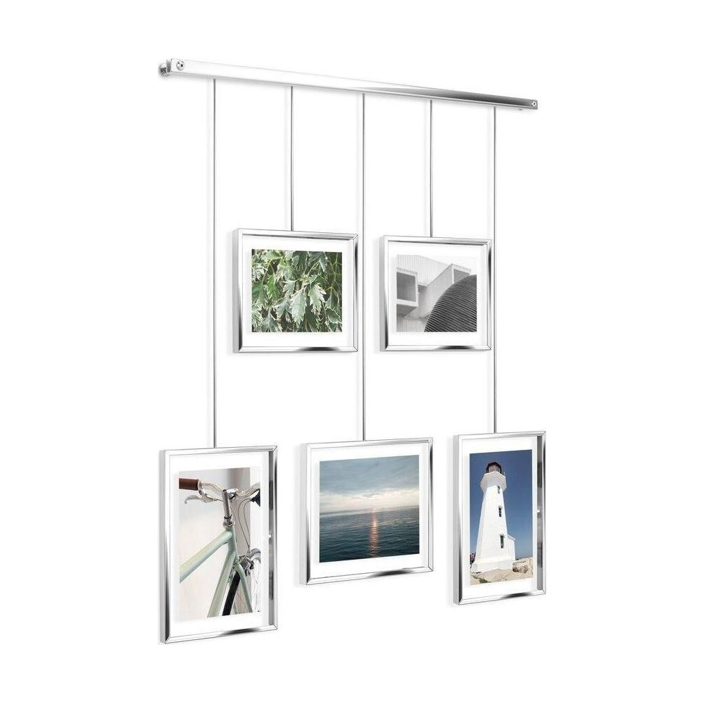 Fünf Bilderrahmen hängen an Schnüren. Eines zeigt Blätter, eines eine Fassade, eines ein Fahrrad, eines ein Meer und eines einen Leuchtturm.