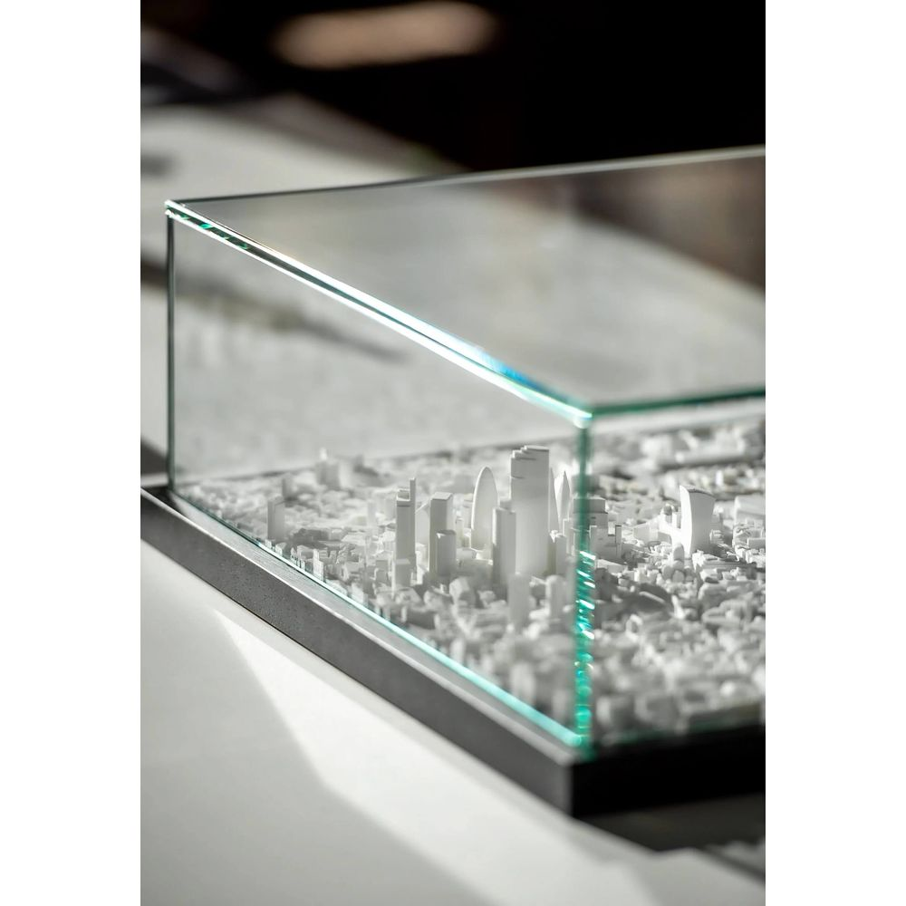 Une maquette de ville blanche avec de hauts bâtiments sous verre.