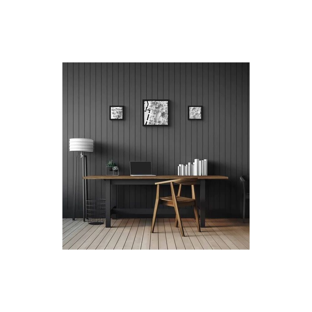 Un bureau avec ordinateur portable, lampe, chaise et tableaux muraux.