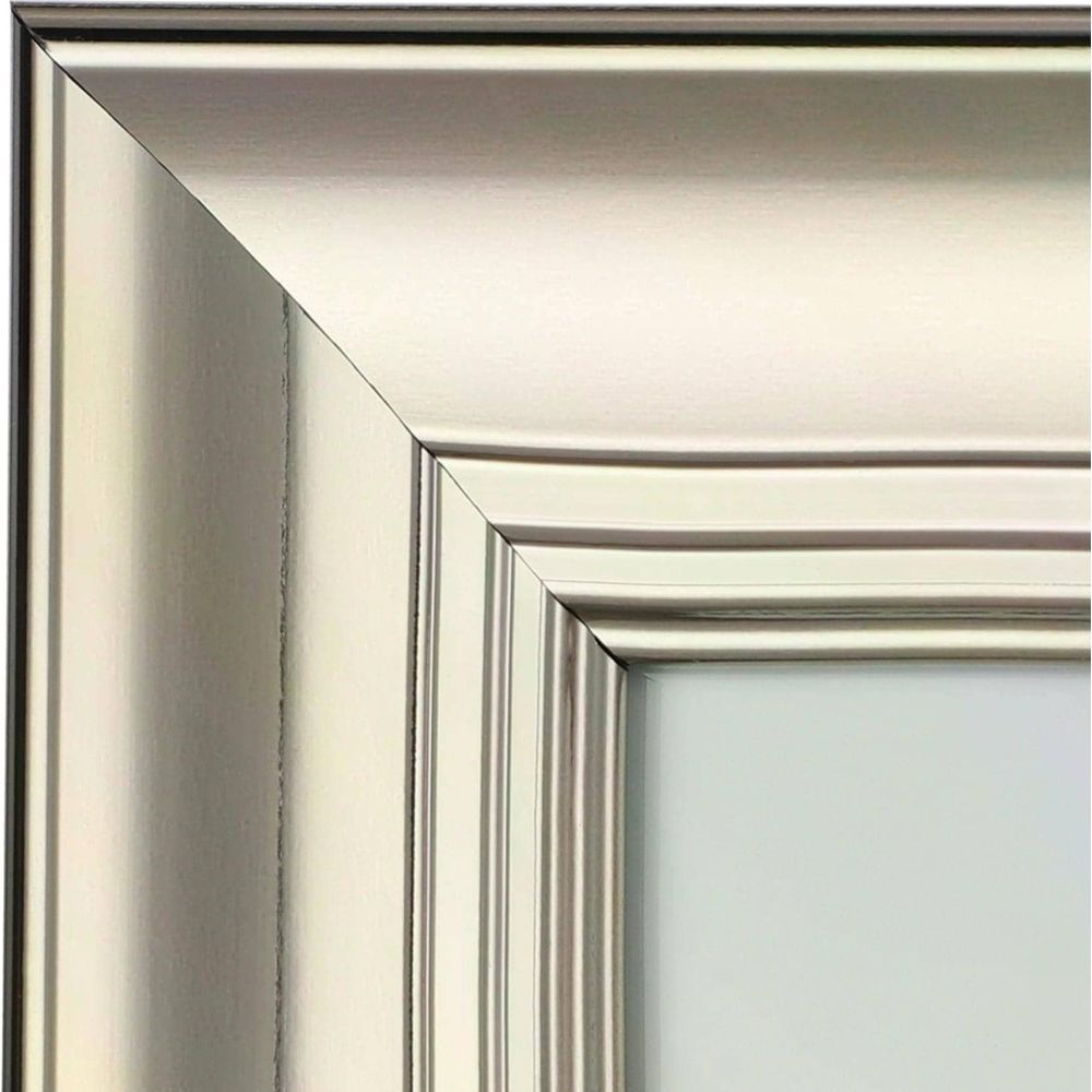 Un primo piano di un angolo di cornice d'argento con scanalature verticali e bordi arrotondati.