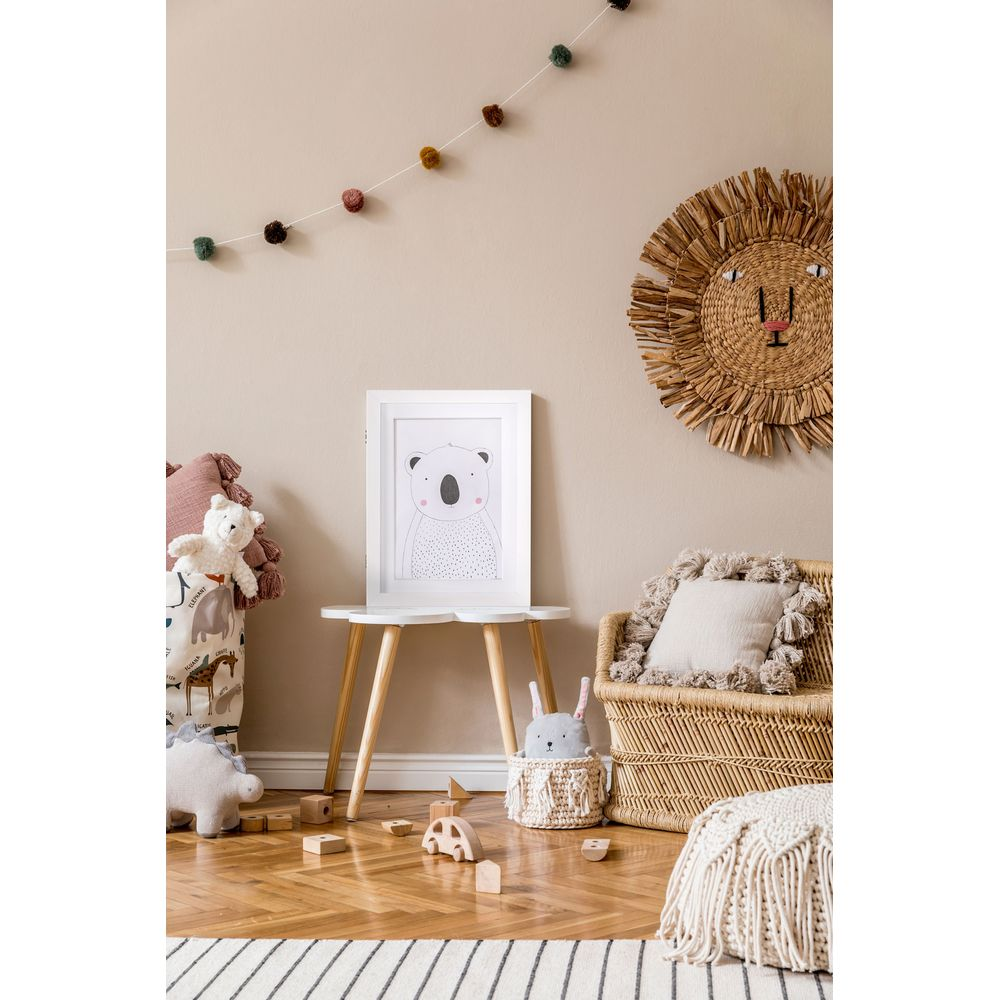 Chambre d'enfant avec dessin de koala sur table et peluches.