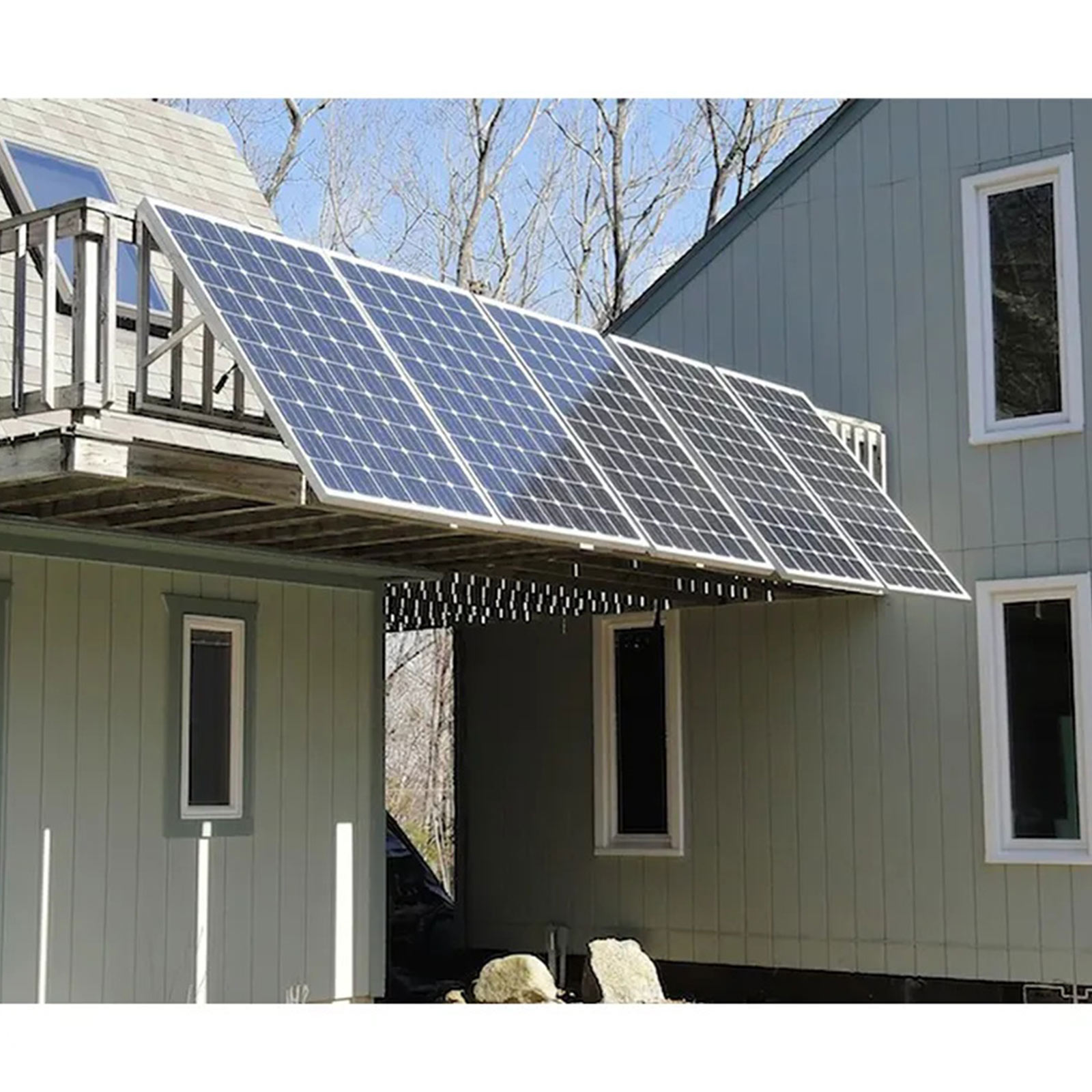 Solarmodule sind auf einem Hausdach montiert. Sie sind von Bäumen umgeben.