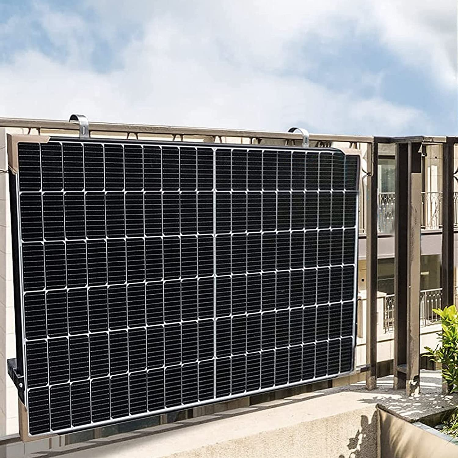 Ein Solarmodul ist an einem Balkongeländer befestigt, mit einem Gebäude im Hintergrund.