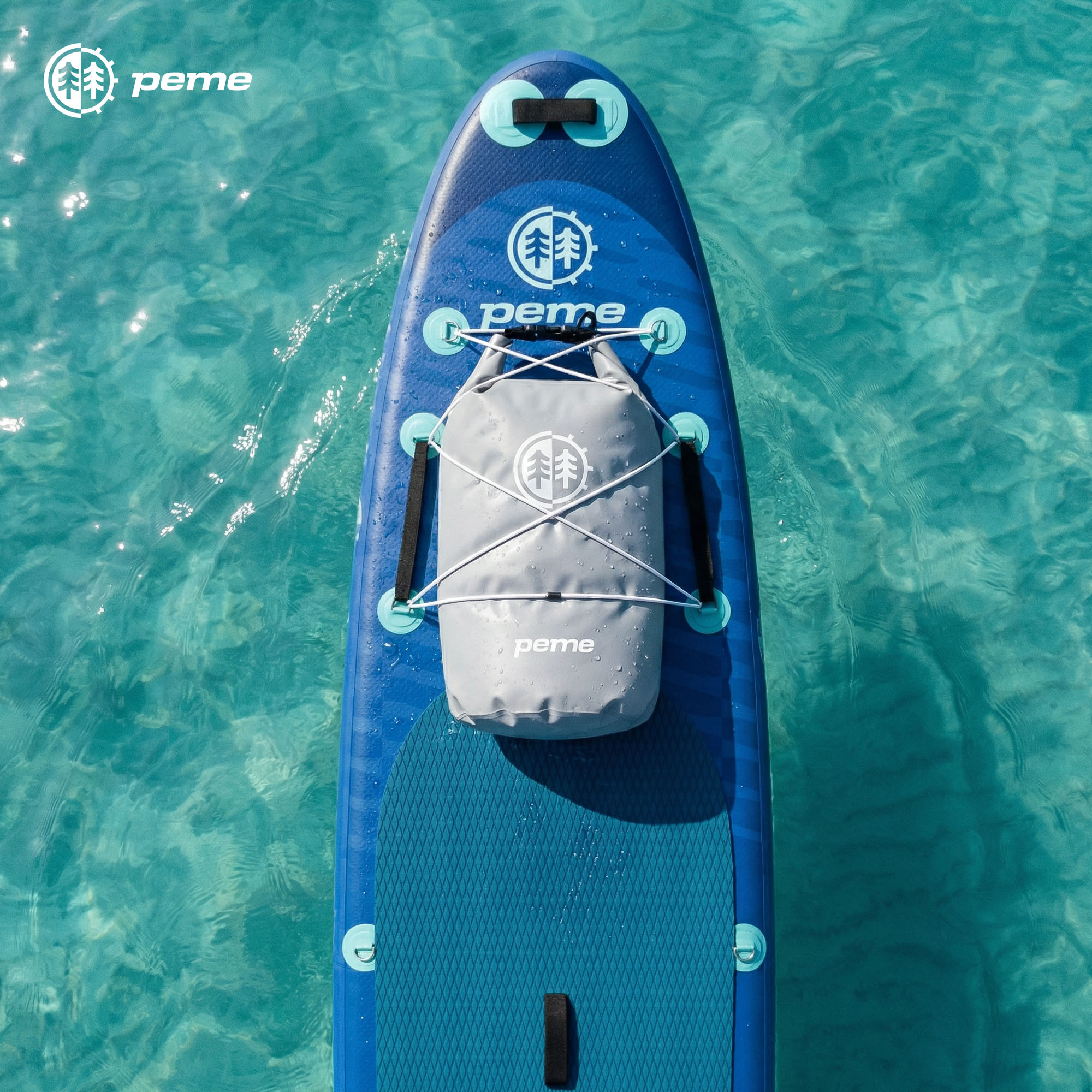 Een blauw paddleboard met een grijze dry bag op helder water.