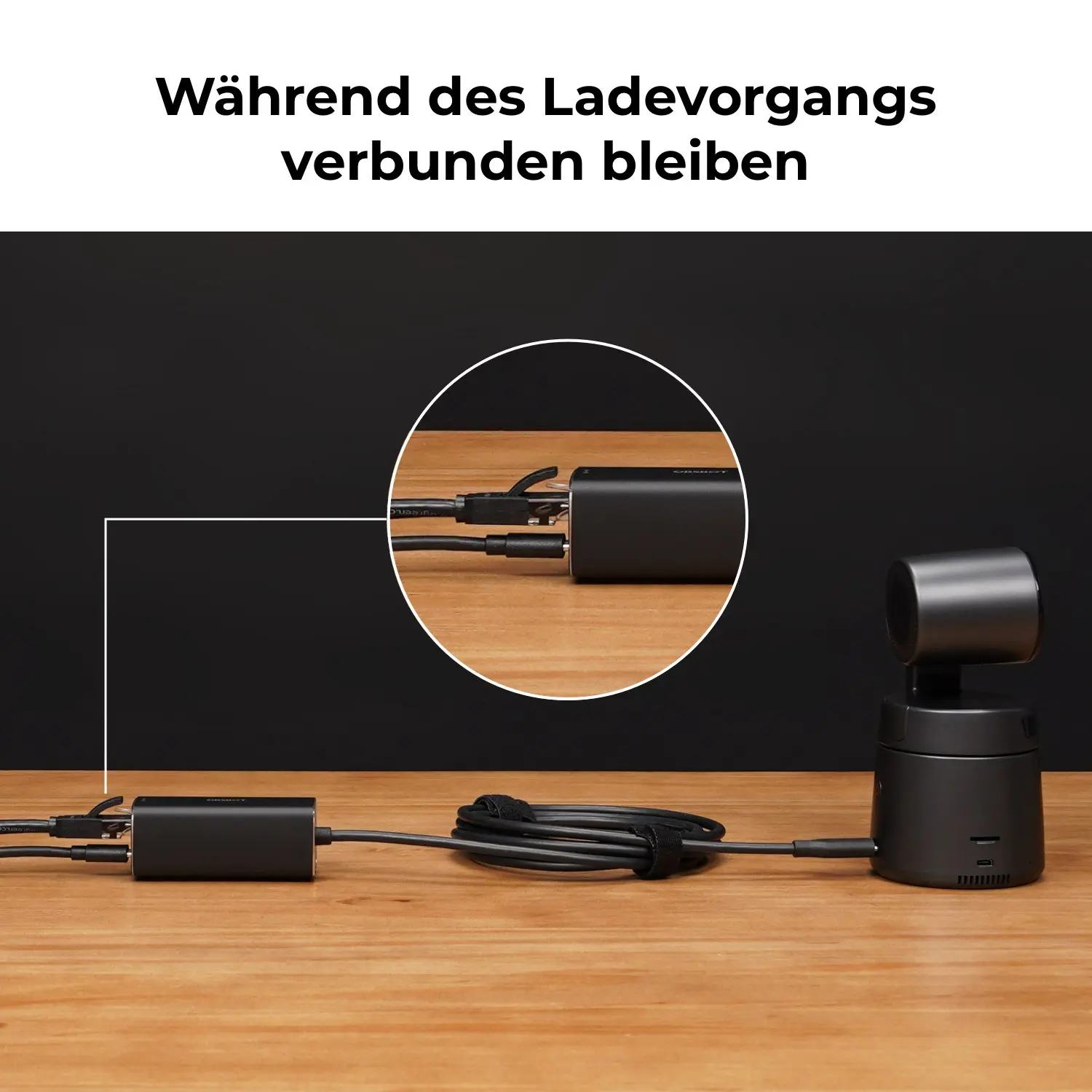 Schwarzer Adapter mit Kabeln und Kamera auf Holztisch