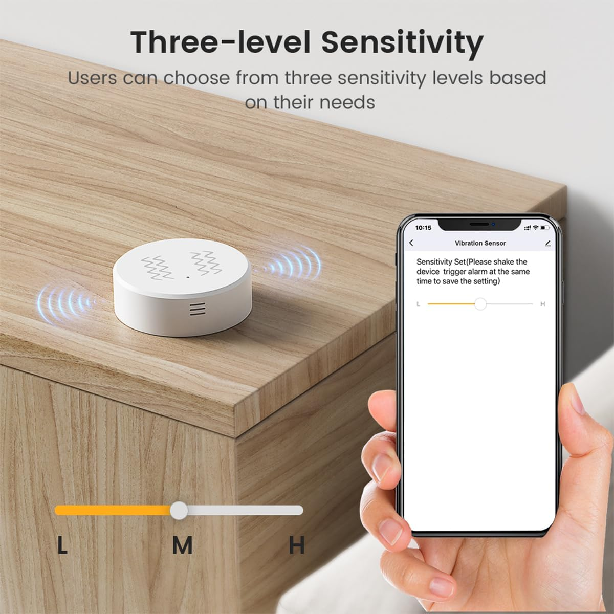 Ein weißer Vibrationssensor auf Holz. Ein Handy zeigt Empfindlichkeitseinstellungen.