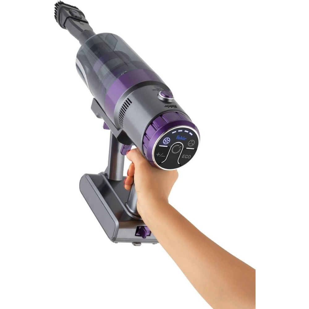 Una mano tiene un aspirapolvere senza fili grigio e viola con spazzola.