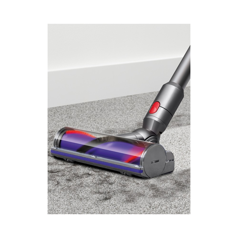 Gri halı üzerinde fırçalı Dyson elektrikli süpürge başlığı.