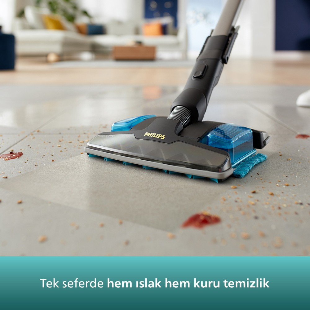 Bir Philips elektrikli süpürge, dökülmüş sıvılar ve kırıntılarla fayans zemini temizliyor.