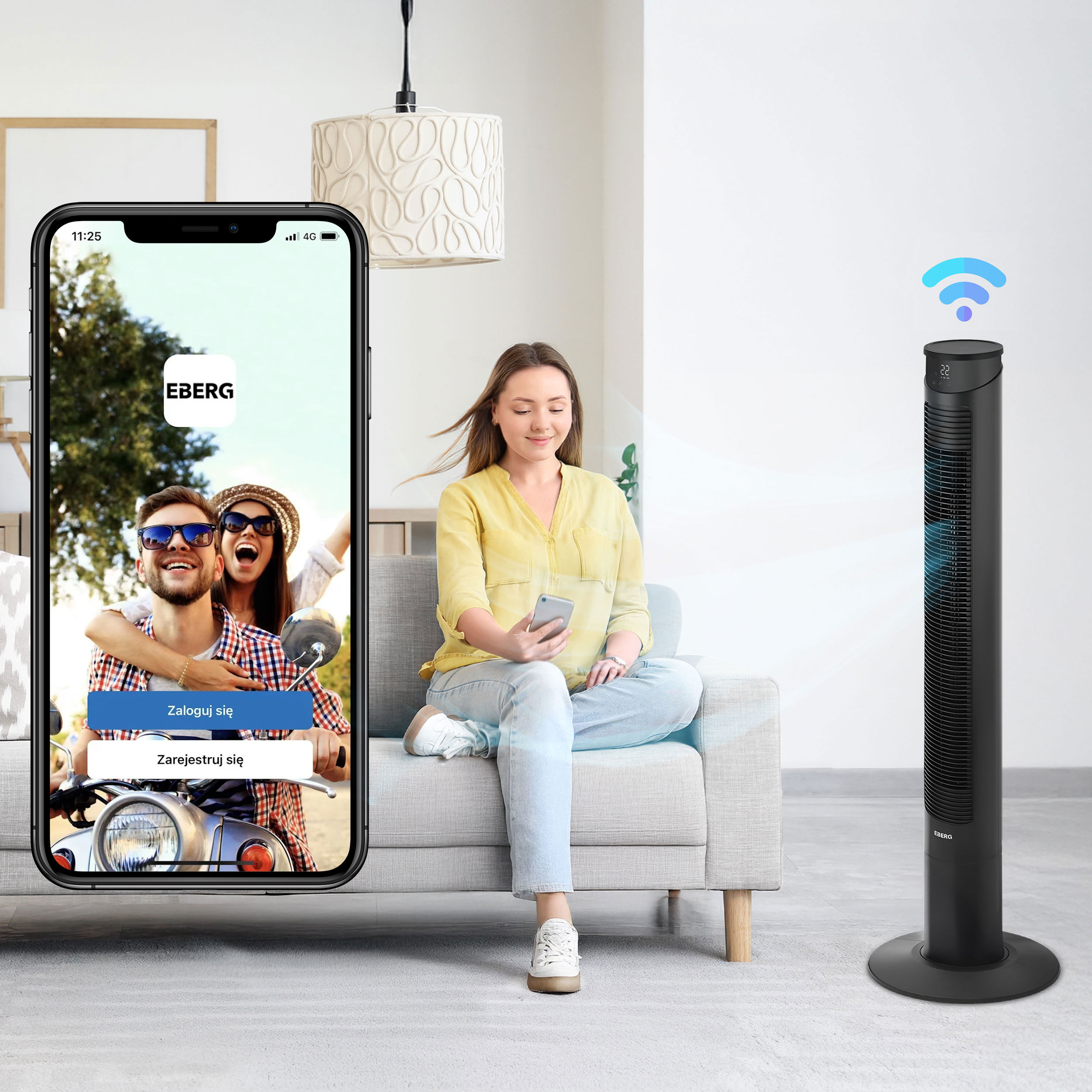 Kobieta siedzi na kanapie, patrząc na telefon. Obok stoi wentylator wieżowy.