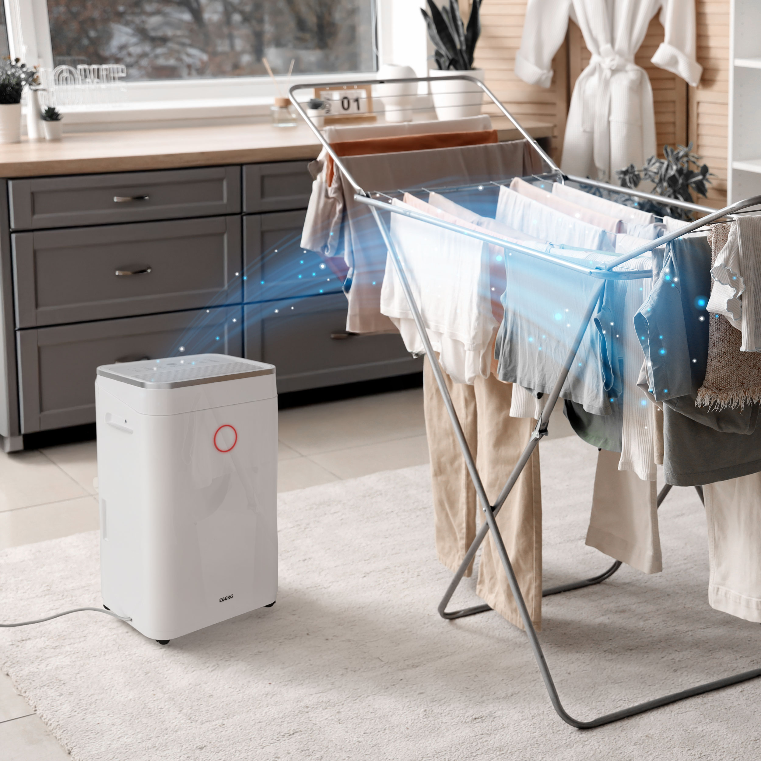 Biały osuszacz powietrza suszy ubrania na stojaku.