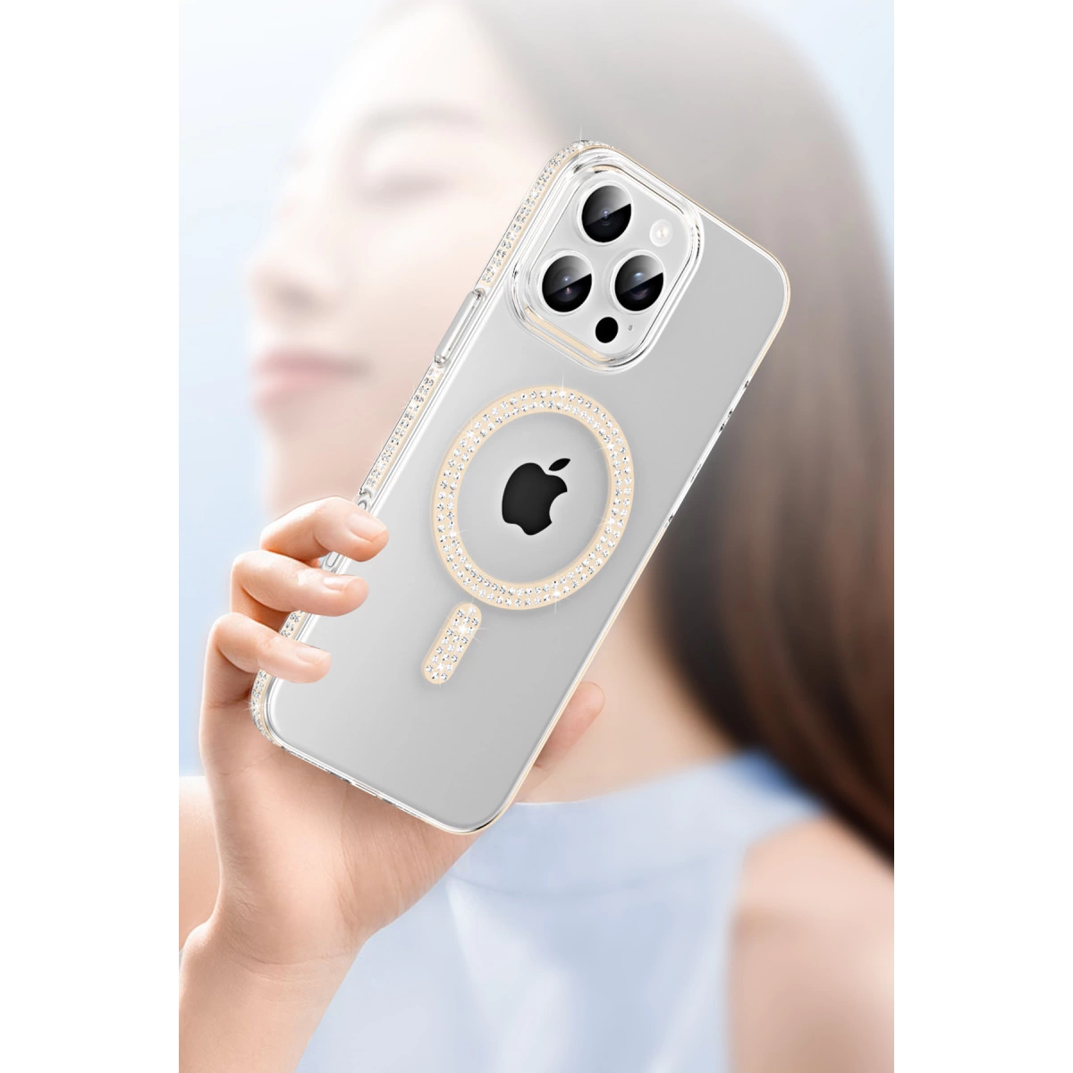 Bir el, şeffaf, kristal işlemeli kasaya sahip bir iPhone tutuyor.