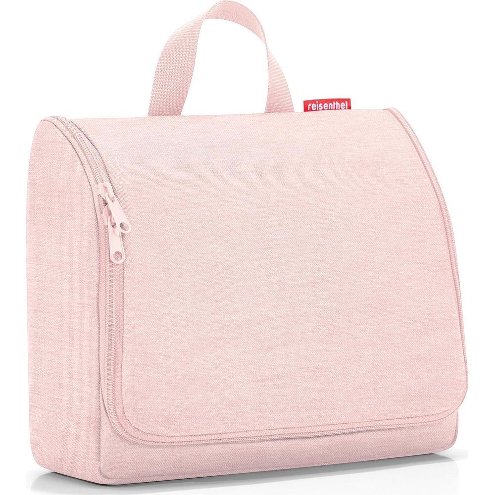 Eine rosafarbene Kulturtasche mit Reißverschluss und Henkel. Ein rotes Etikett zeigt 'reisenthel'.