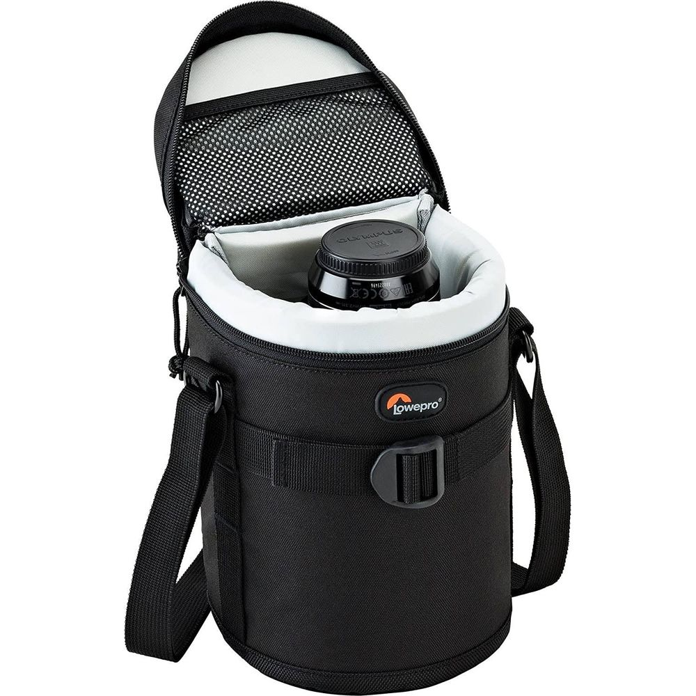 Eine schwarze Lowepro Tasche mit offenem Deckel, darin eine Objektivkappe.