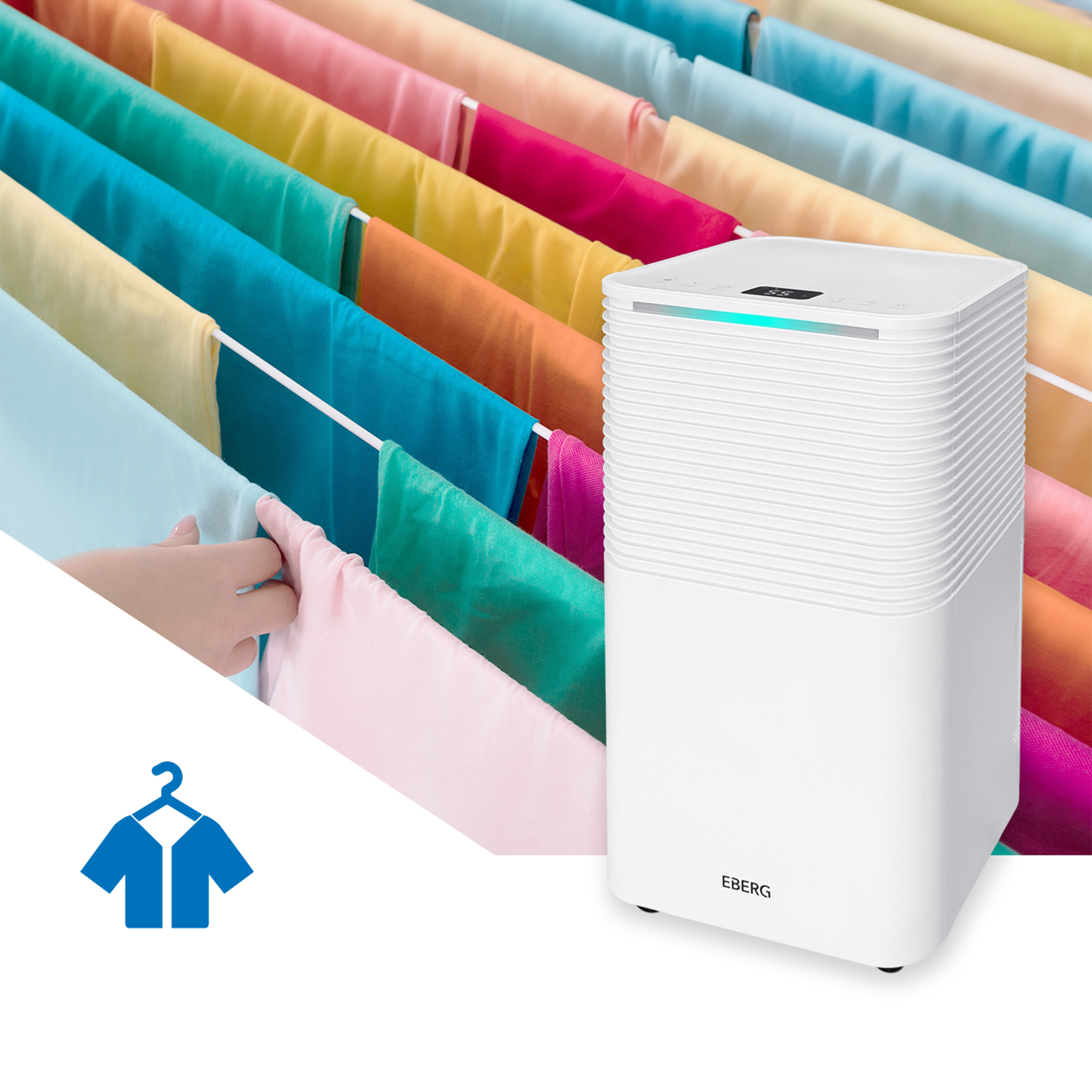 Biały osuszacz powietrza obok kolorowego prania na suszarce.