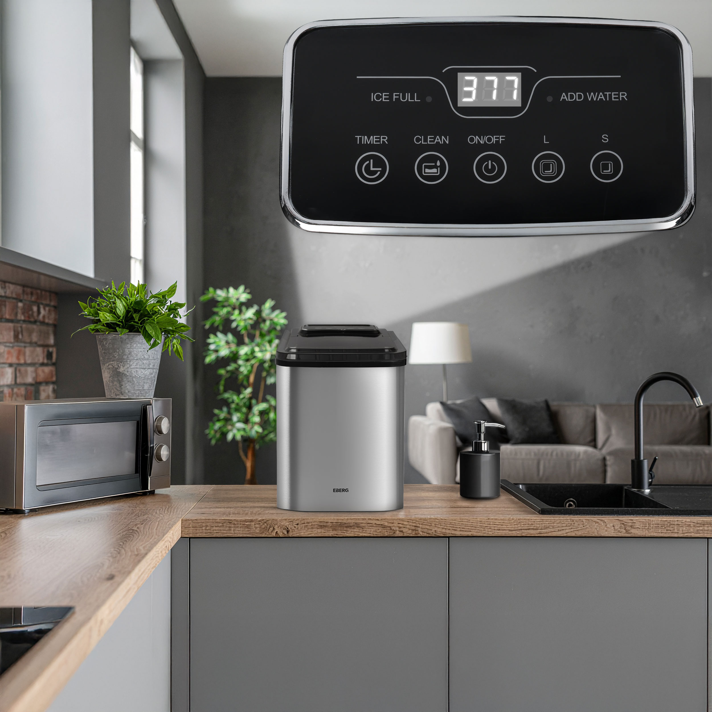 Srebrna kostkarka do lodu na drewnianym blacie obok kuchenki mikrofalowej.