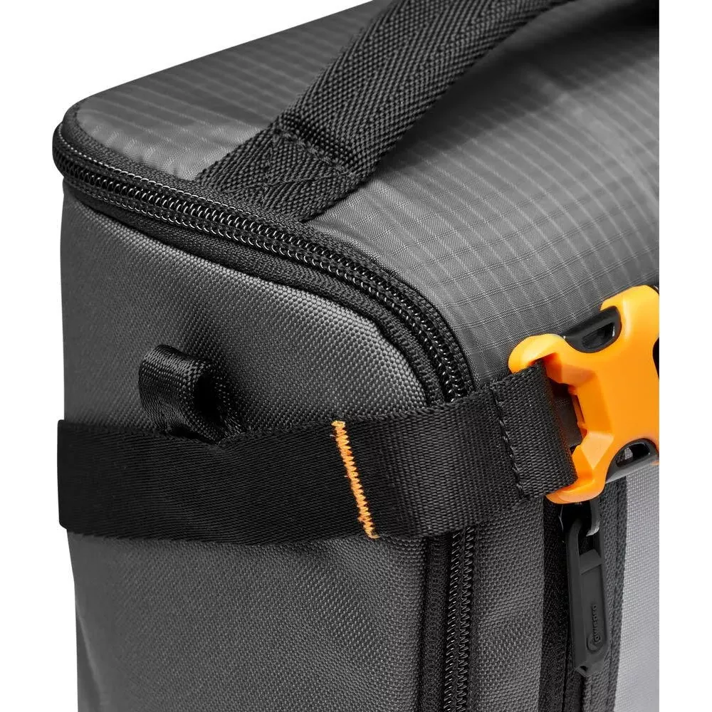 Borsa grigia con cerniera, manico e clip arancione.