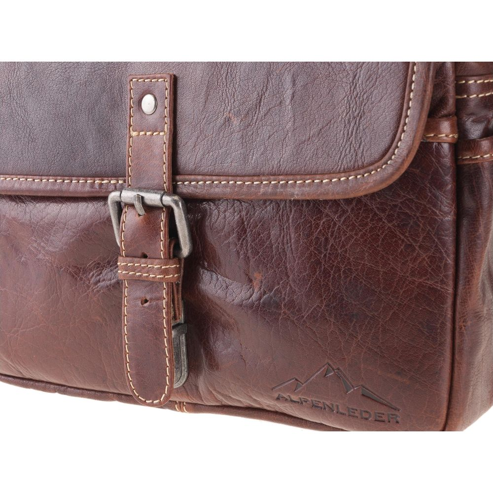 Borsa in pelle marrone con fibbia e rilievo montano. Primo piano.