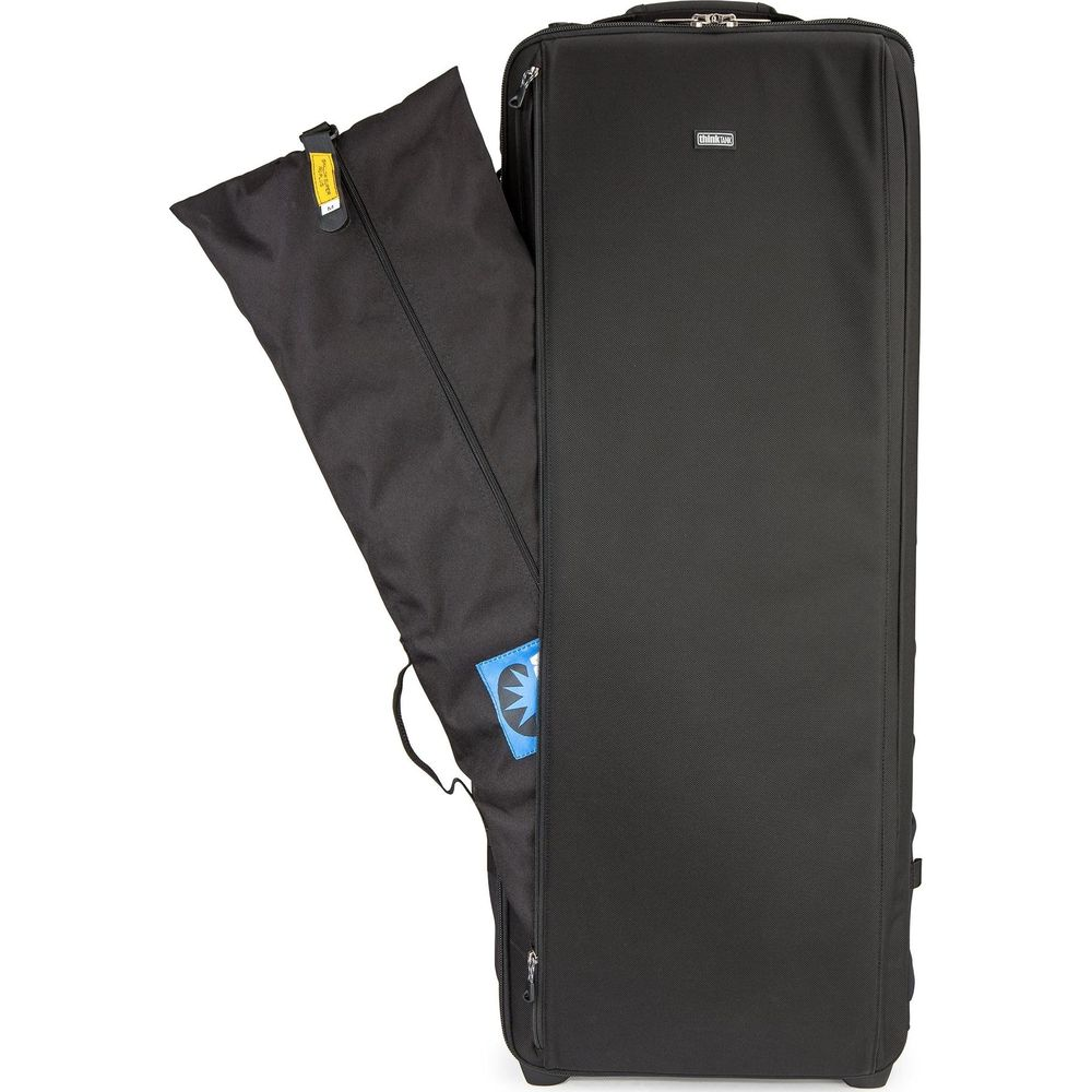 Schwarze Reisetasche mit geöffnetem Fach, aus dem ein schwarzer Stoffbeutel herausragt.