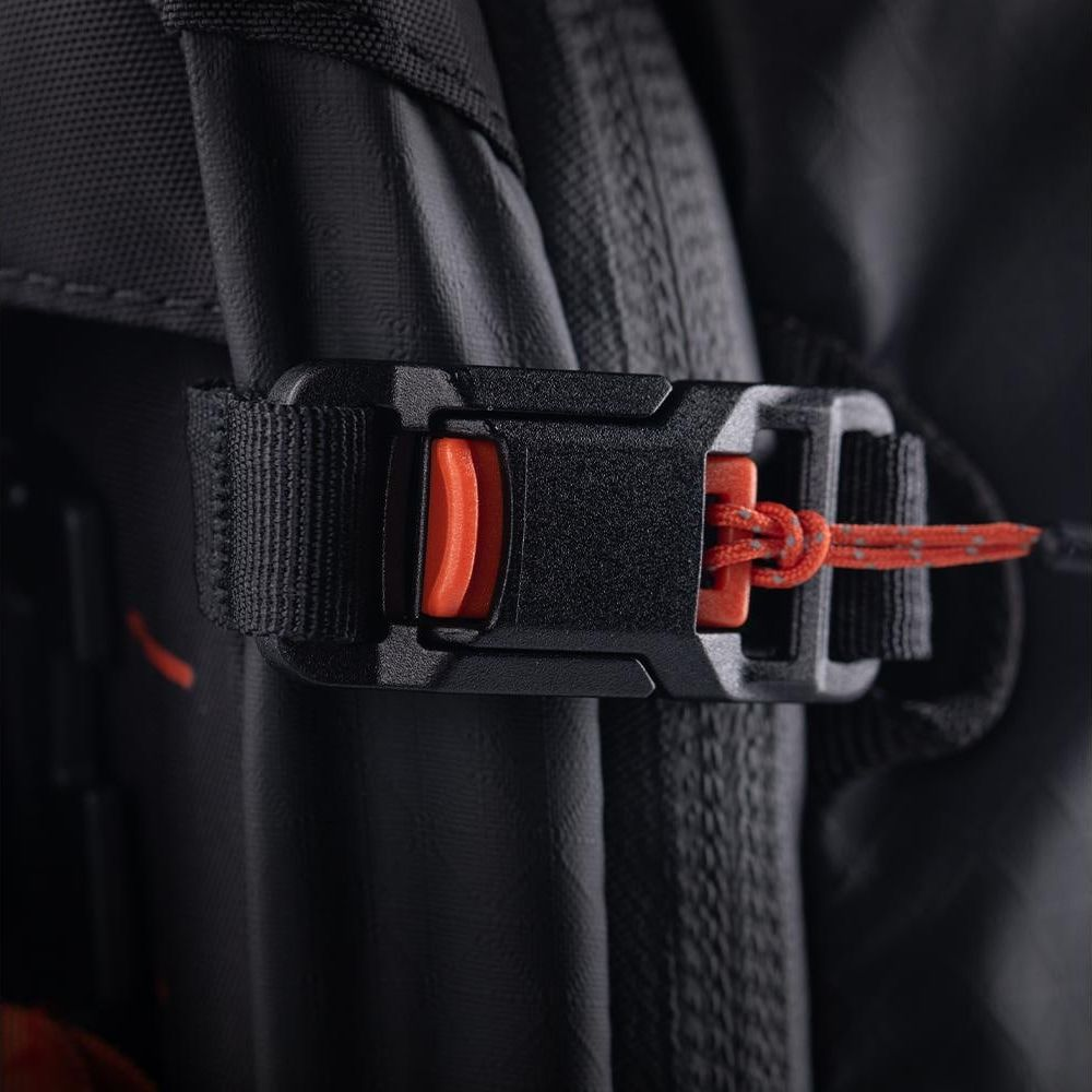 Boucle noire de sac à dos avec cordon orange et accent rouge.