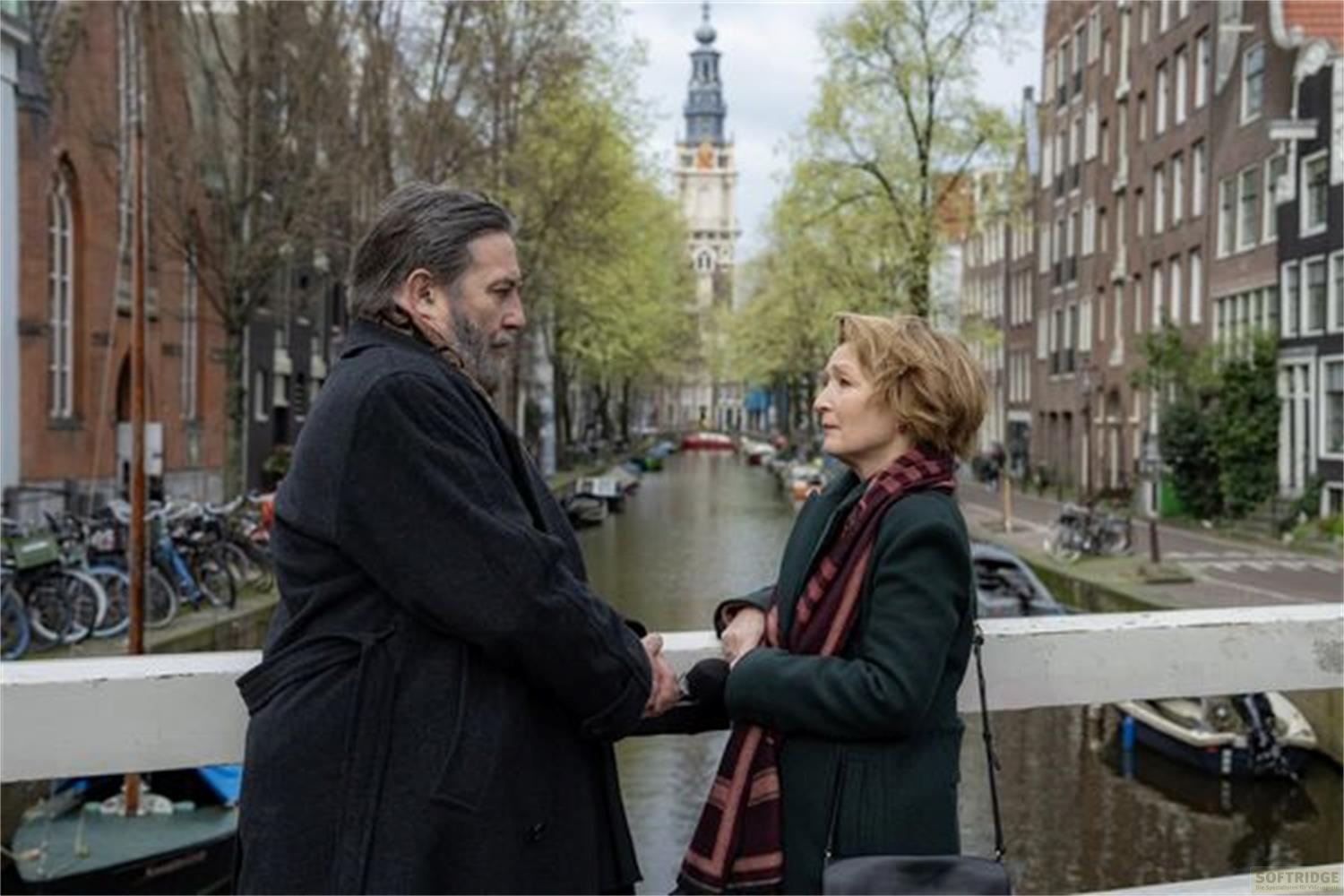Un uomo e una donna sono su un ponte ad Amsterdam, si guardano.