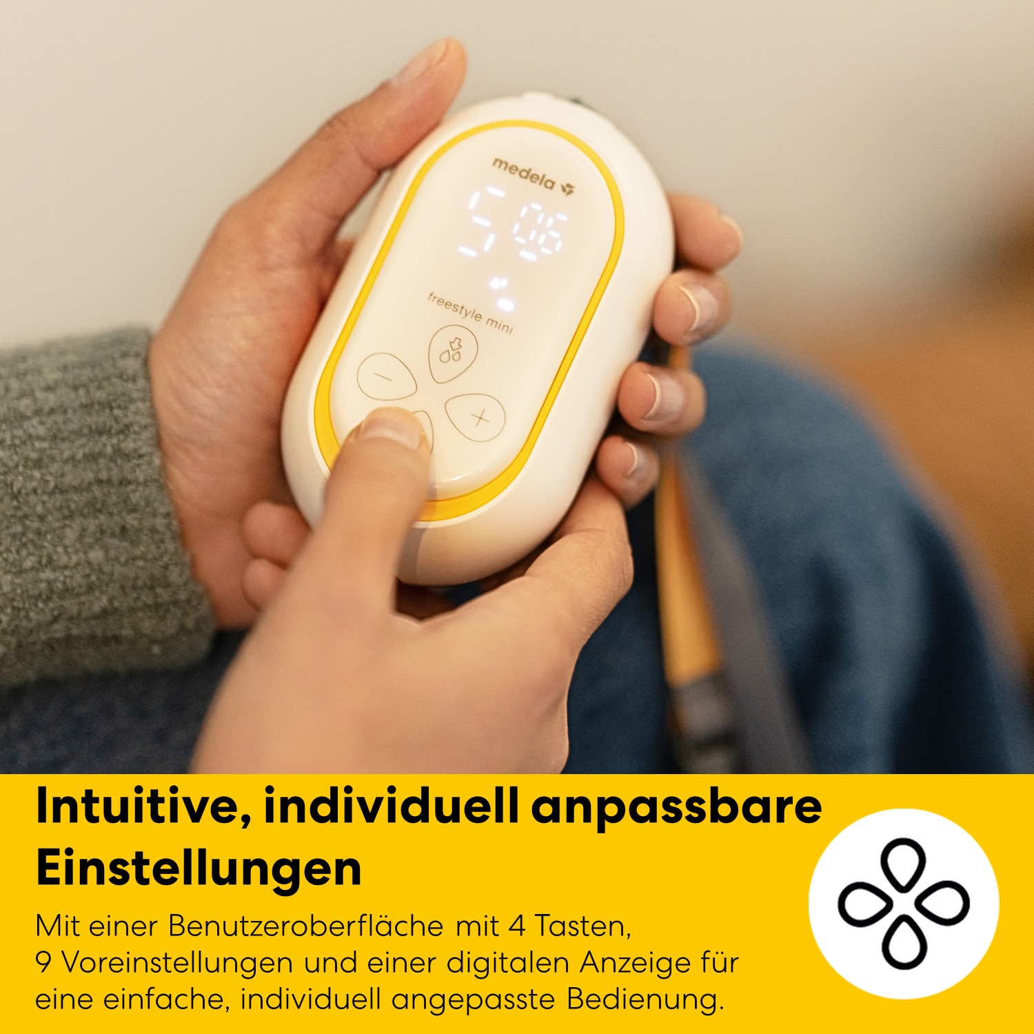 Eine Hand hält ein Medela Freestyle Mini Milchpumpen-Bedienfeld mit Display und Tasten.