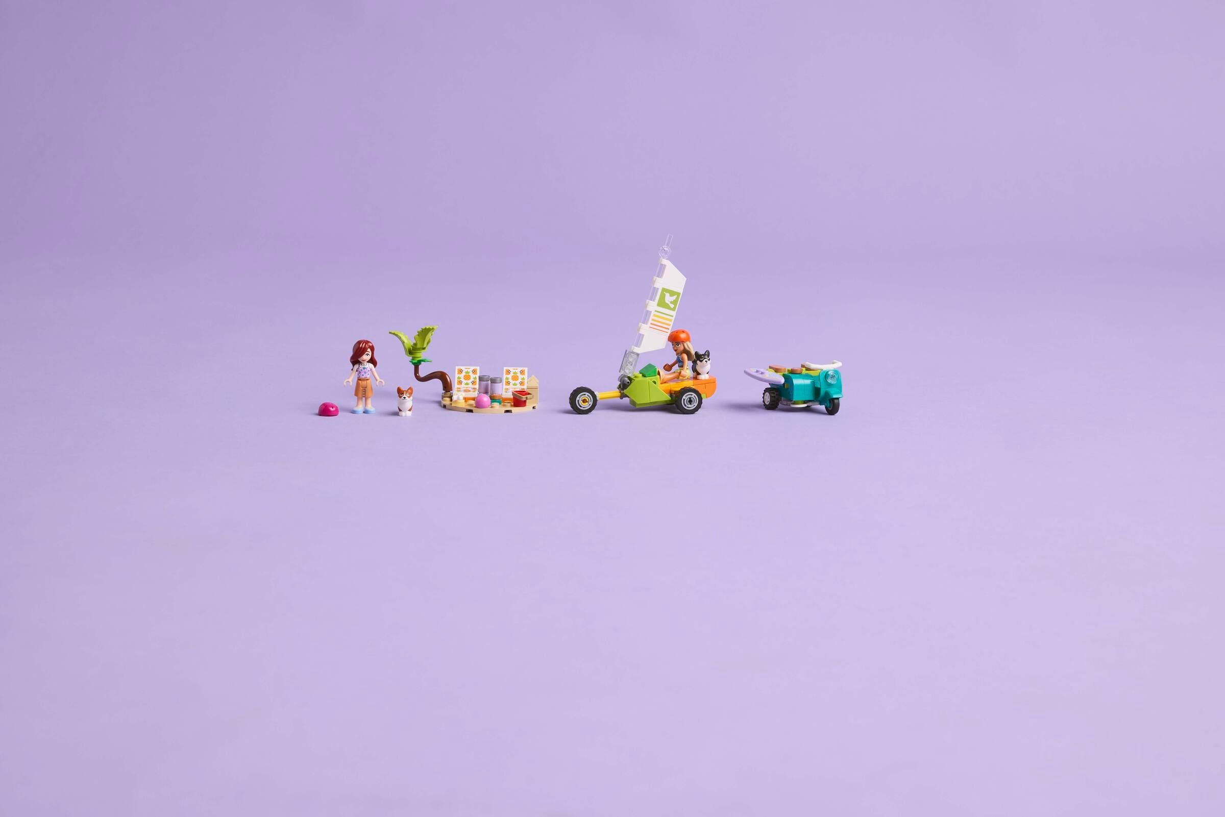 Lego-Figuren: Frau, Hund, Segelwagen, Roller auf lila Hintergrund.