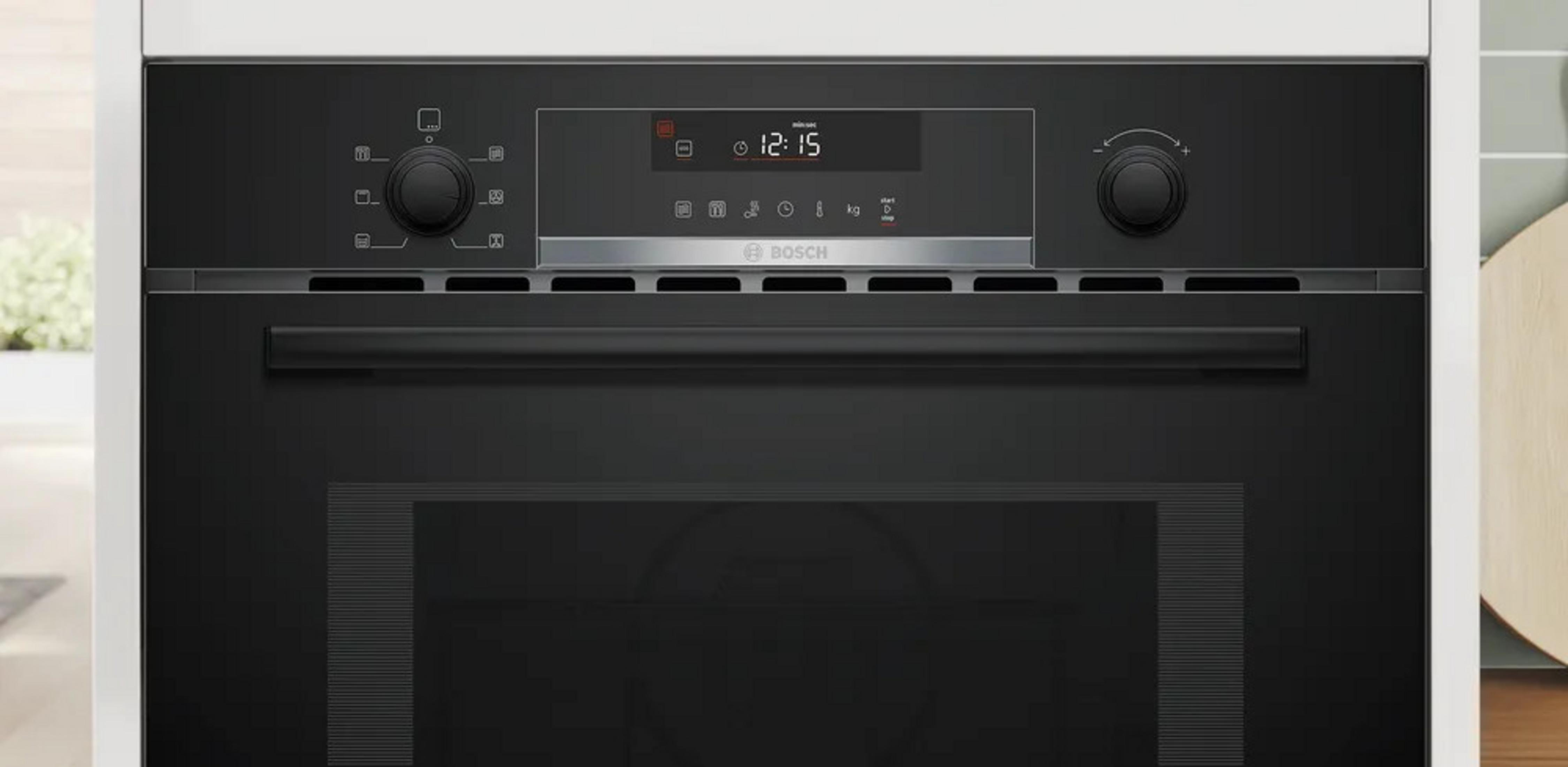 Zwarte Bosch oven met digitaal display, knoppen en handvat.
