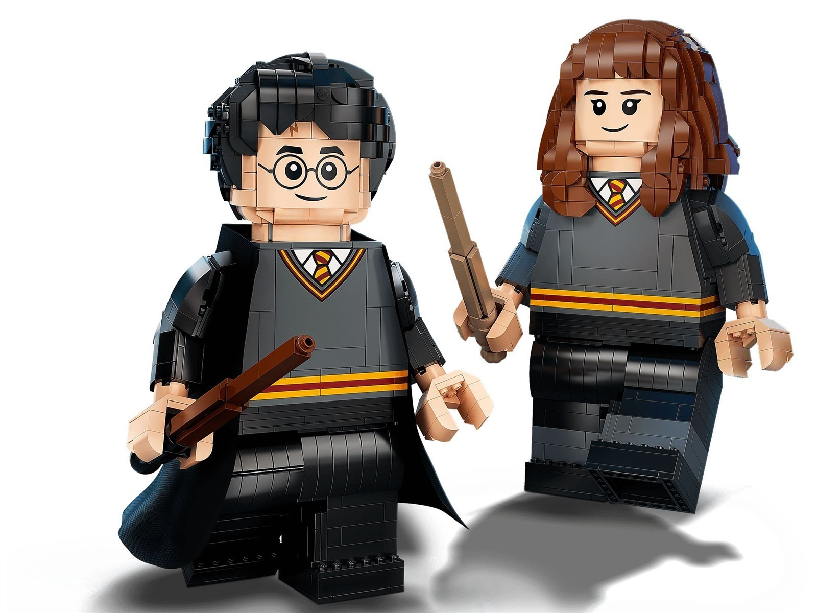 Lego-Figuren von Harry Potter und Hermine Granger in Schuluniformen, mit Zauberstäben.