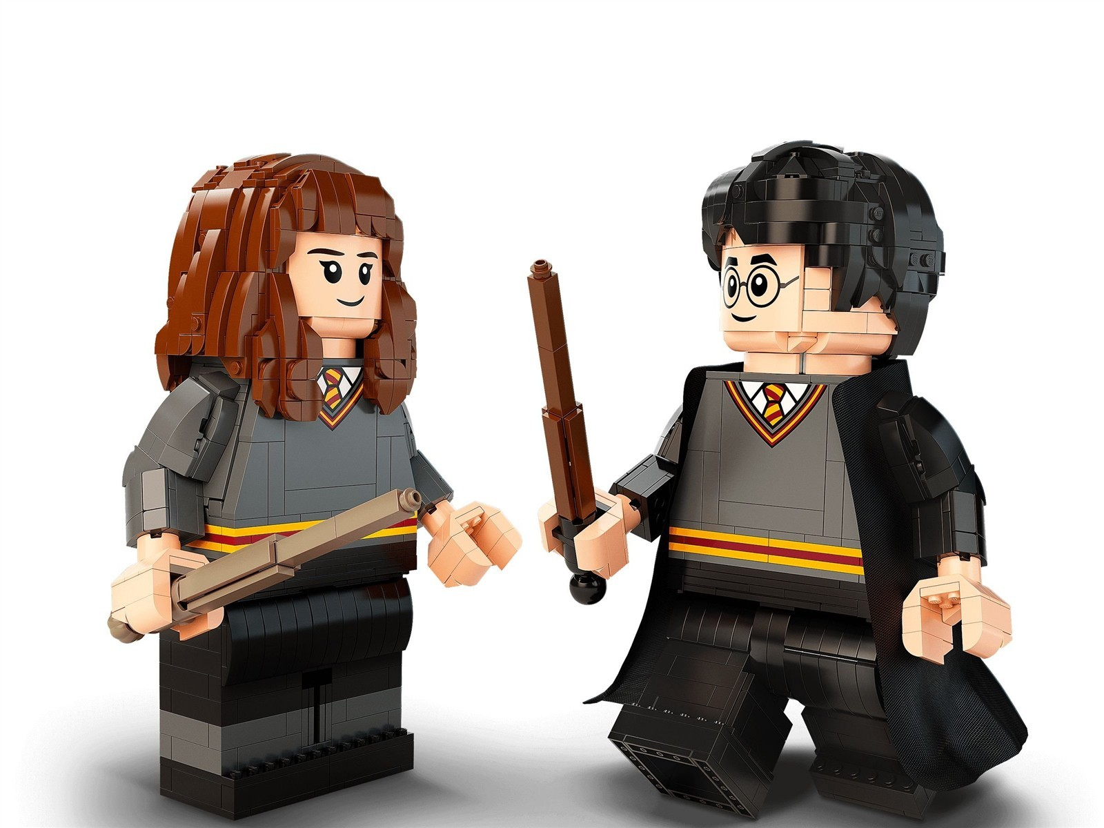 Zwei Lego-Figuren, Harry und Hermine, halten Zauberstäbe. Sie tragen Schuluniformen.